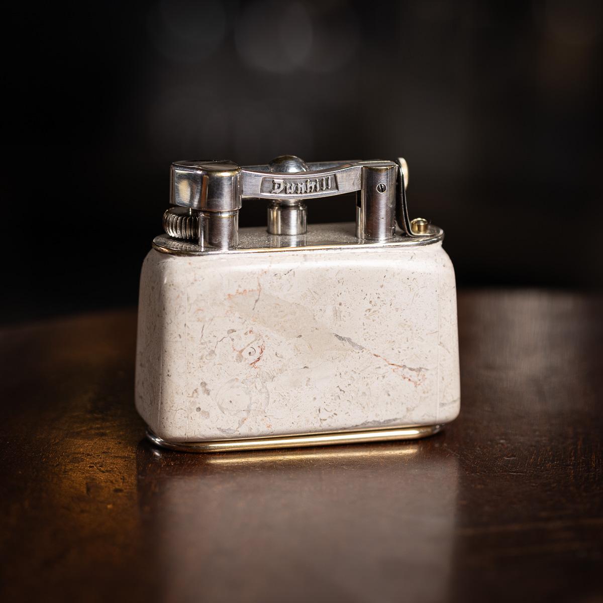 Un meraviglioso accendino da tavolo Dunhill del XX secolo, con un meccanismo placcato in argento e un sorprendente corpo rivestito in marmo travertino italiano. Timbrato nella parte inferiore 