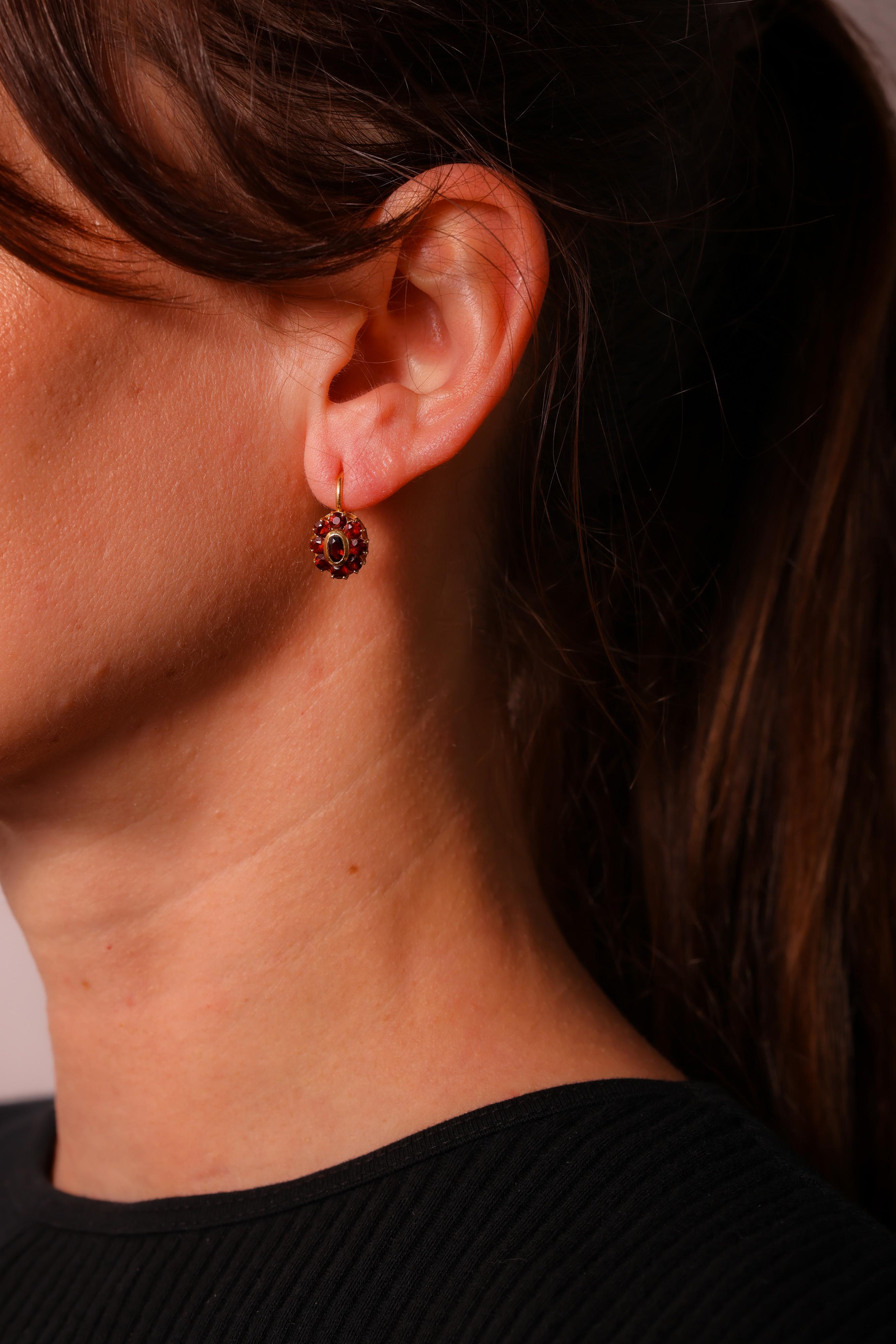 Center Stone: 2 Garnets
Cut: Oval Cut
Weight: Approximately 0.5 Carats
Color: Red
Accent Stone: 16 Garnets
Cut: Round Brilliant Cut
Weight: Approximately 1.6 Carats
Color: Red
Metal: 18K Yellow Gold
Era: Vintage
Circa: 1980s
Hallmarks: Numbered,