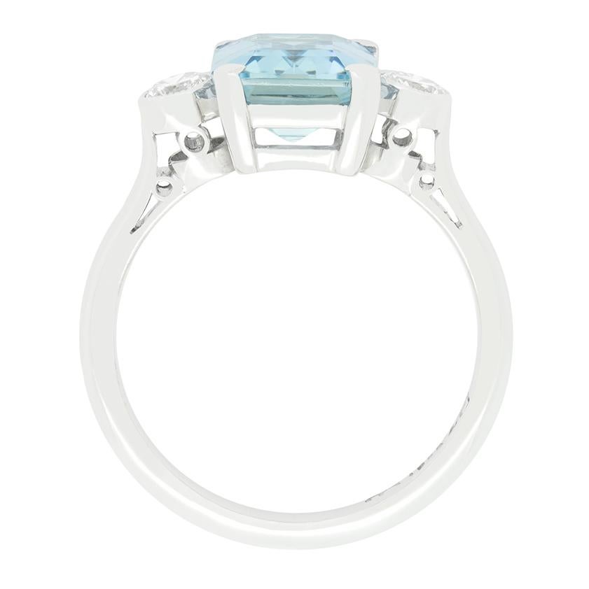 This 1940s trilogy ring features a stunning 2.15 carat aquamarine at its centre. The emerald cut aquamarine is a beautiful pale blue colour flanked by a pair of 0.20 carat round brilliant diamonds. These diamonds match in quality at G in colour and