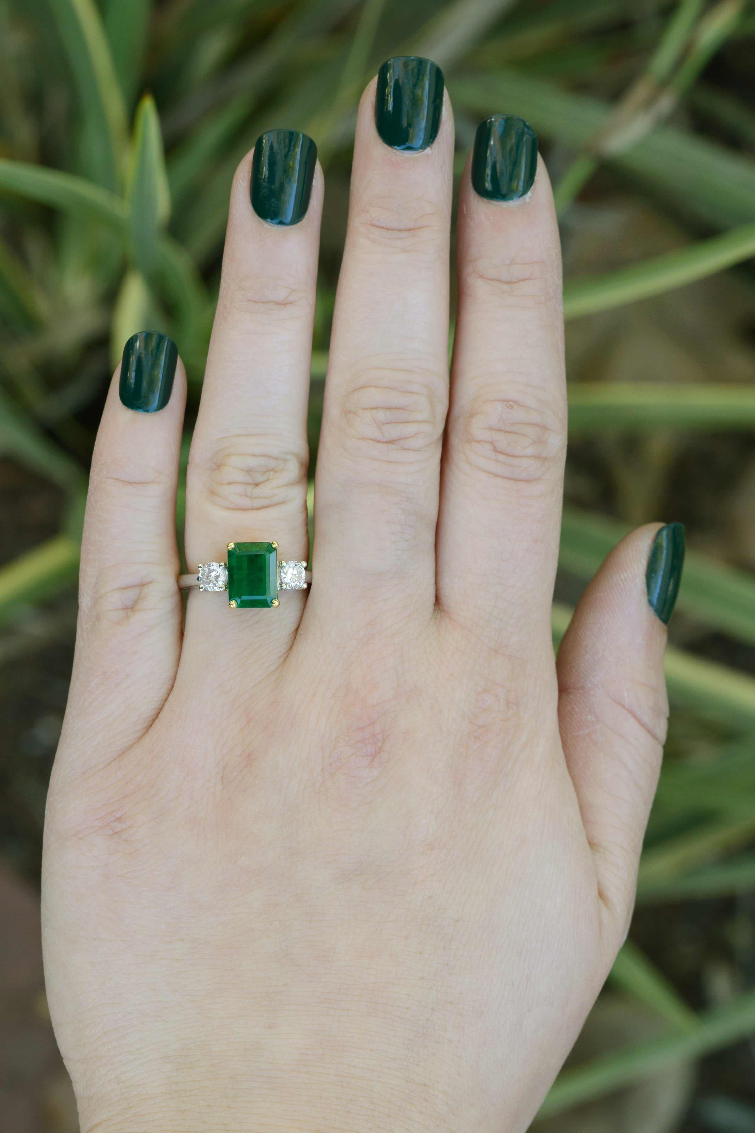 The Tahoe vintage 2.17 carat emerald and diamond engagement ring is a classic, 3 stone trilogy or trinity design. Centered by a richly-toned natural emerald of a vivid, forest green and smartly accented by a pair of sparkling, brilliant diamonds,