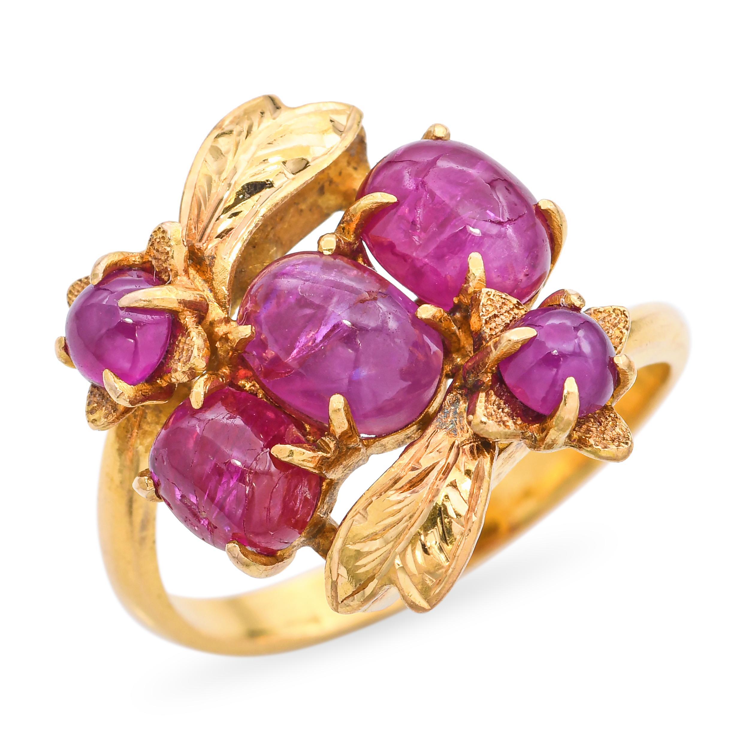 Dieser exquisite Vintage-Ring ist aus 21 Karat Gelbgold gefertigt und zeigt eine Gruppe von Sternrubinen, die in einem zarten floralen Motiv angeordnet sind. Jeder Rubin zeigt bei direktem Lichteinfall einen sanften Asterismus, der dem Design Tiefe