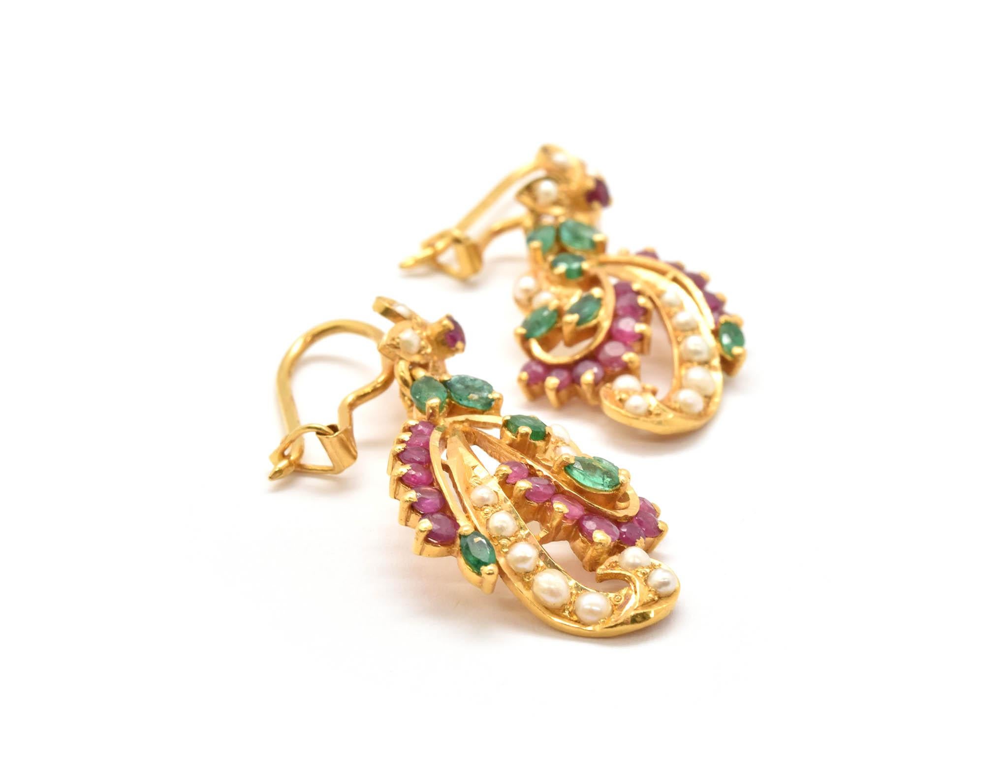 This vintage pair of earrings are fashioned from 22k yellow gold, with emeralds, rubies and pearls artistically mounted in the 22k yellow gold prong settings! Rubies and emeralds are cut in round, oval and marquise shapes. Each earring has 14 seed