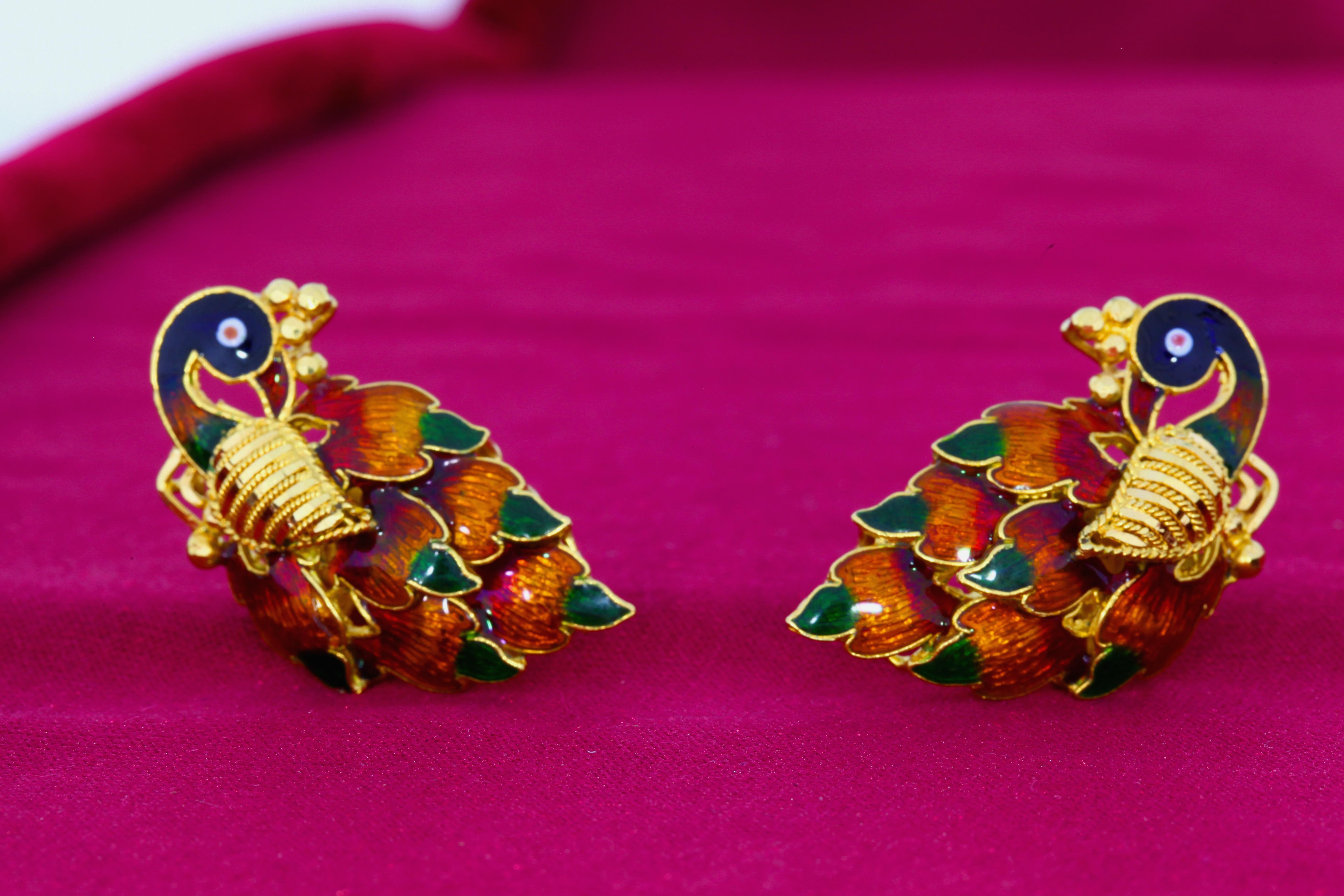 These earrings in 22 karat gold feature bright colors and detailed enamel work bringing the peacock imagery to life.