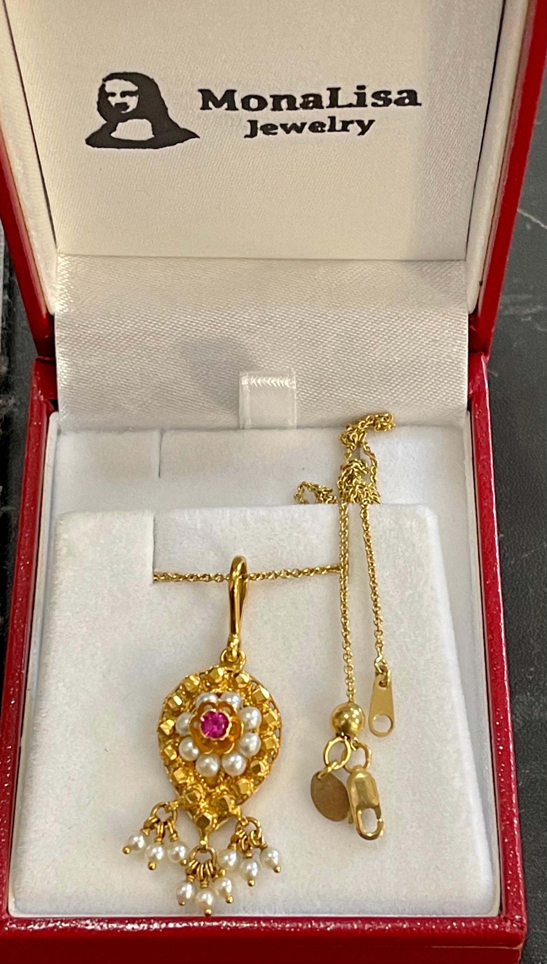 Vintage 22 Karat Yellow Gold Pendant Necklace With 18 Karat Yellow Gold Chain
This spectacular Pendant Necklace  consisting of single ruby and many small natural pearls.

22k Gold pendant and 18 K gold chain 7.2 Grams 
The pendant comes with a 18 K
