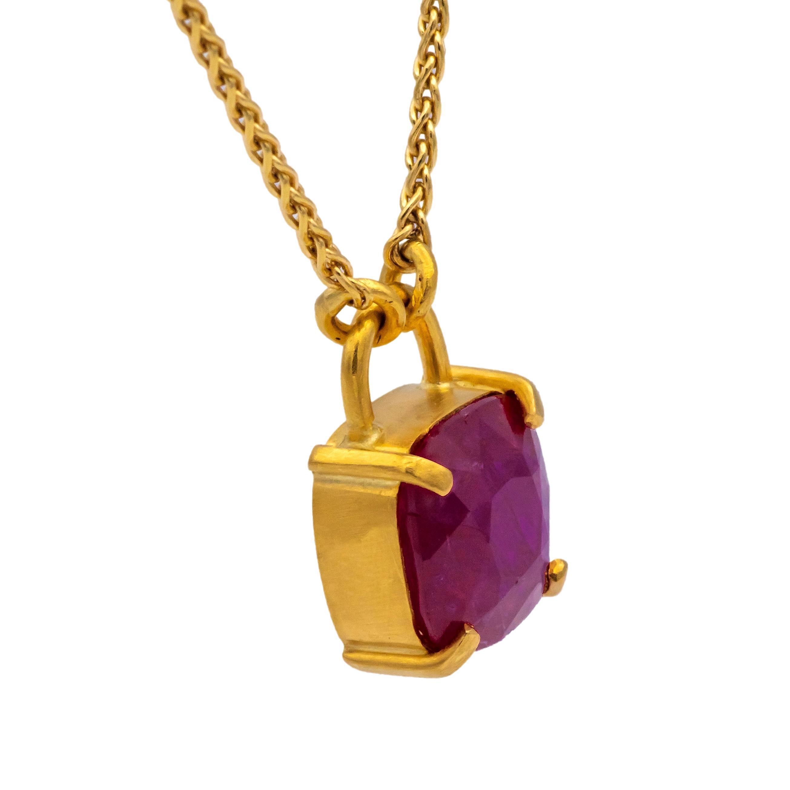 Adquirido originalmente en Barneys New York en la década de 1980, este collar colgante de oro de 18K / 22K hecho a mano presenta un rubí talla cojín de aproximadamente 3 quilates, engastado en una caja de oro de 22K hecha a mano. El colgante está