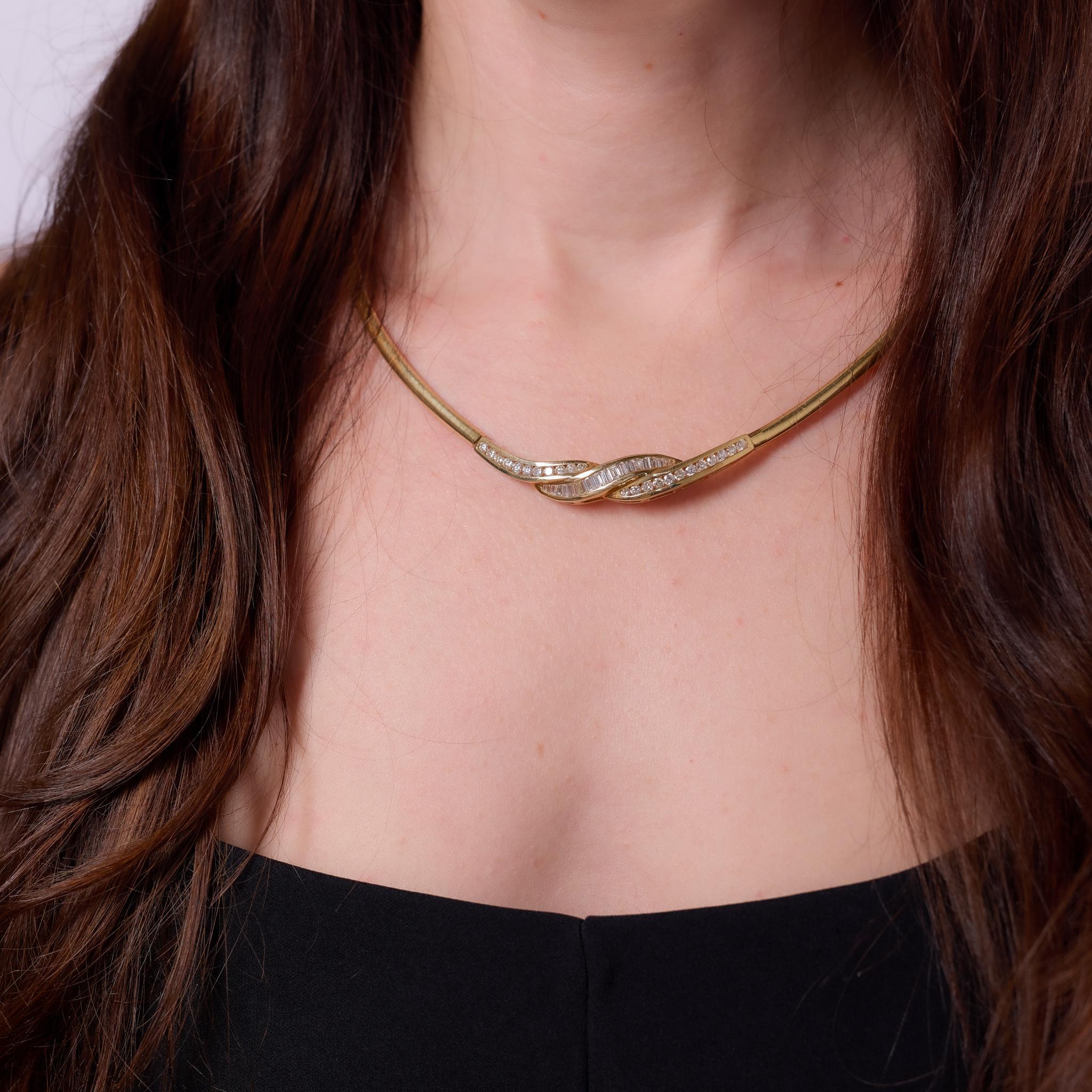Crafted in the 1990s, this vintage necklace is set in 14k yellow gold and showcases a total of 43 round brilliant and baguette cut diamonds, weighing approximately 2.30 carats. Graded G color and VS-SI clarity, the diamonds are arranged in a flowing
