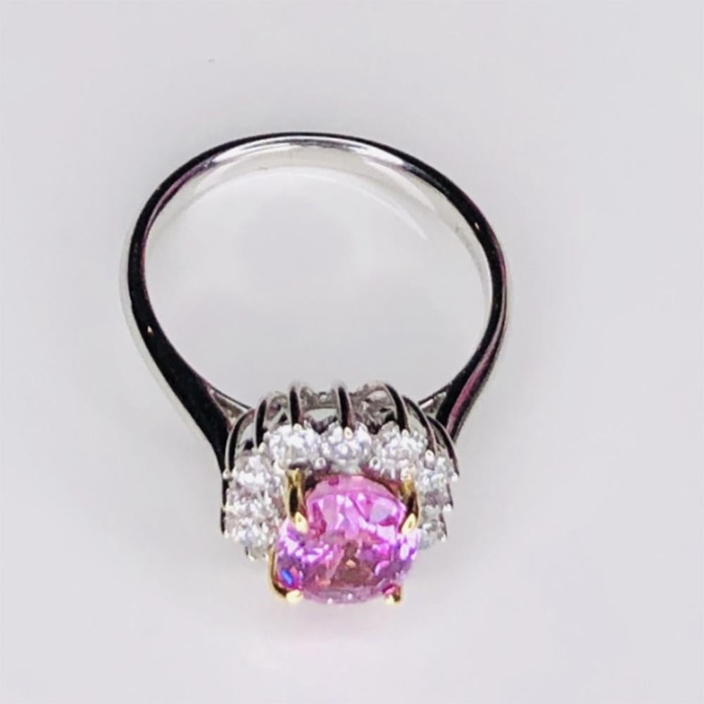 Simply Beautiful! Elegant and finely detailed Mid Century Modern Solitaire Cocktail Engagement Ring, set with a securely nestled 2.32 Carat oval Pink Sapphire surrounded by Brilliant-cut Diamonds, weighing approx. 0.61 total Carat weight.  Circa