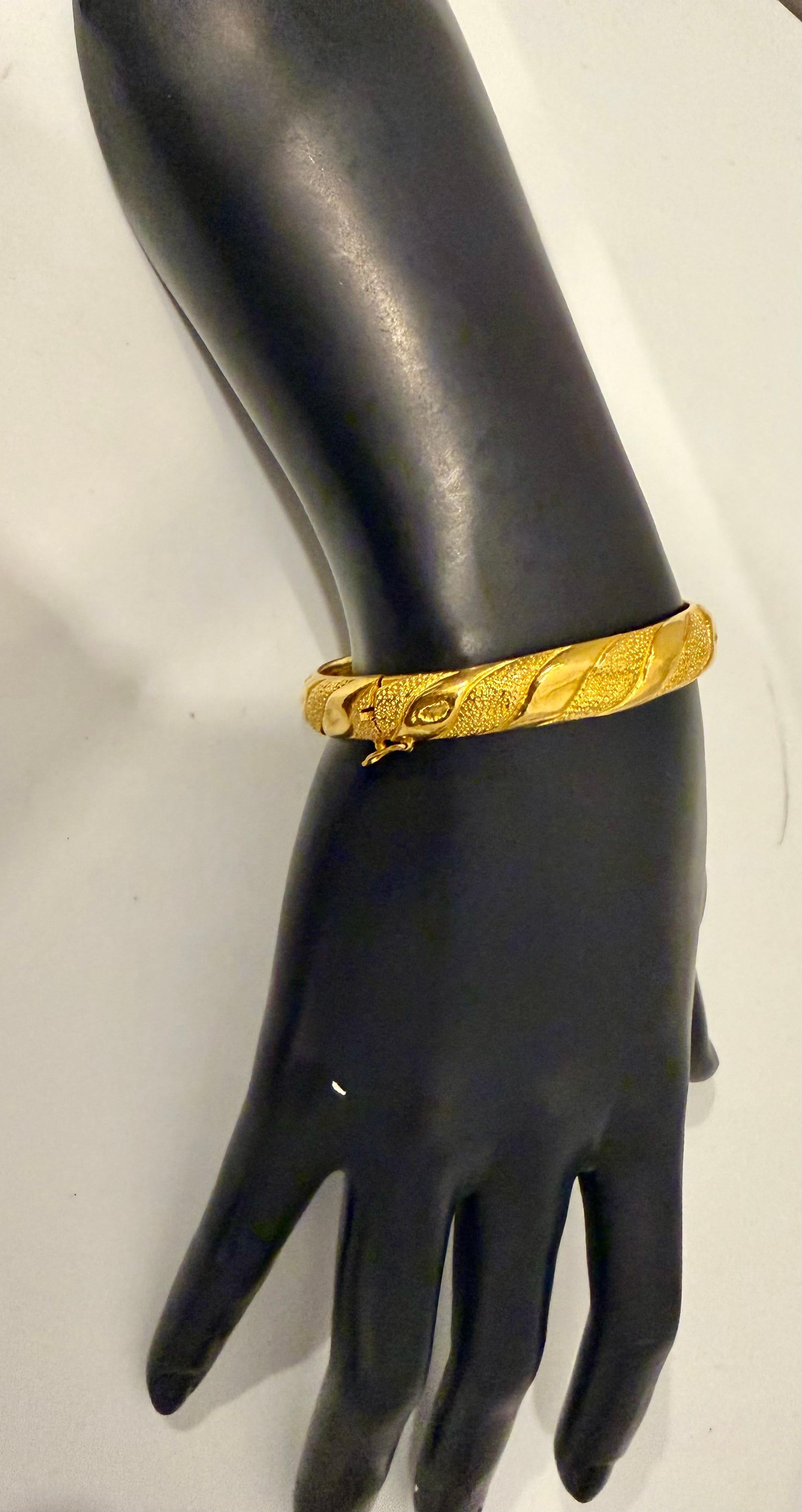 Ce bracelet en or jaune 24 carats  est un magnifique bijou en or massif authentique. Le bracelet  Le bracelet pèse 27,5 grammes et mesure 2,2 pouces de diamètre intérieur, ce qui en fait un ajout substantiel et précieux à toute collection. Le