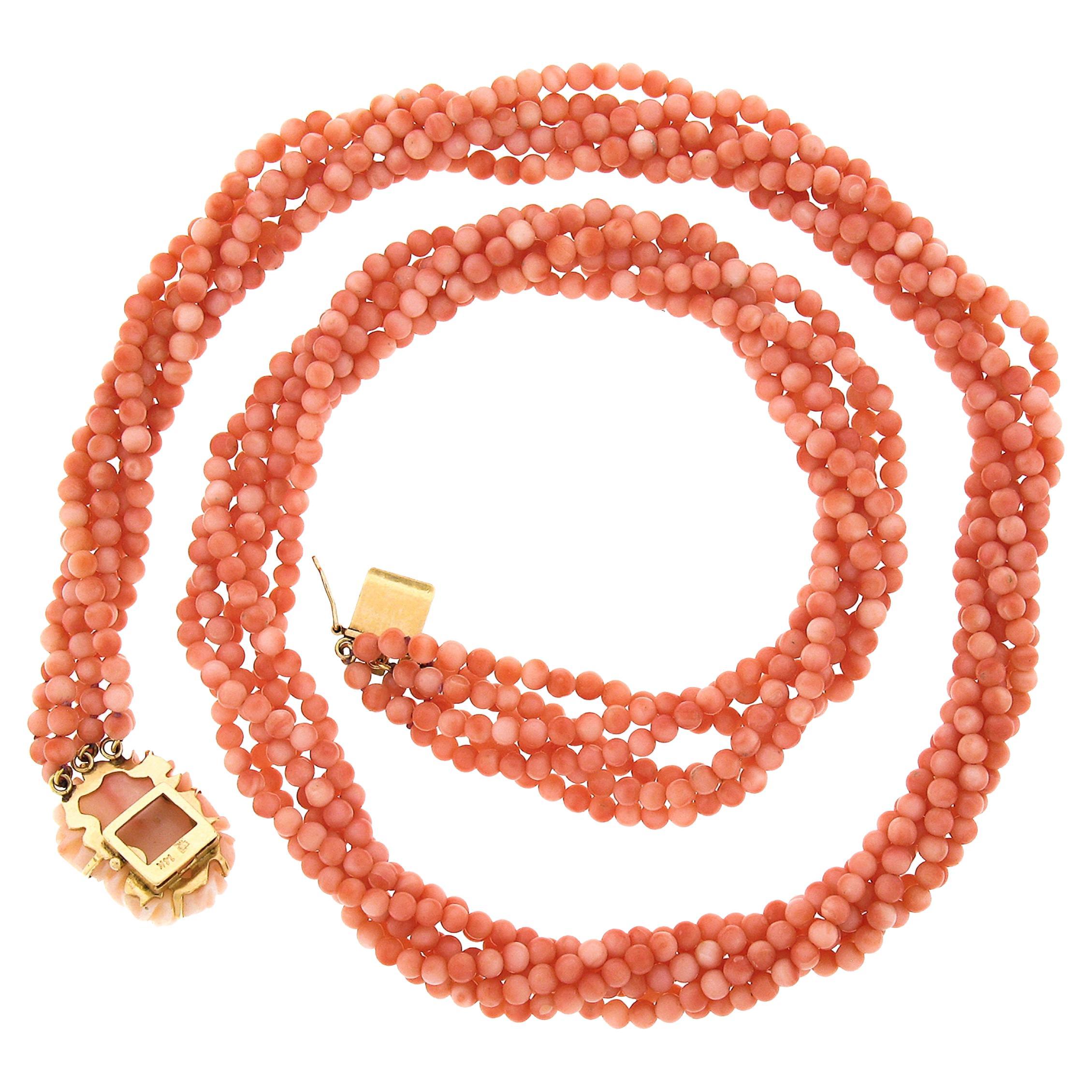 This gorgeous multi-strand coral torsade necklace features 6 strands tied together by a 14k yellow gold box clasp. The Corals are round beads with variation of pink angel skin color. The top of the clasp also features a gorgeous carved flower coral