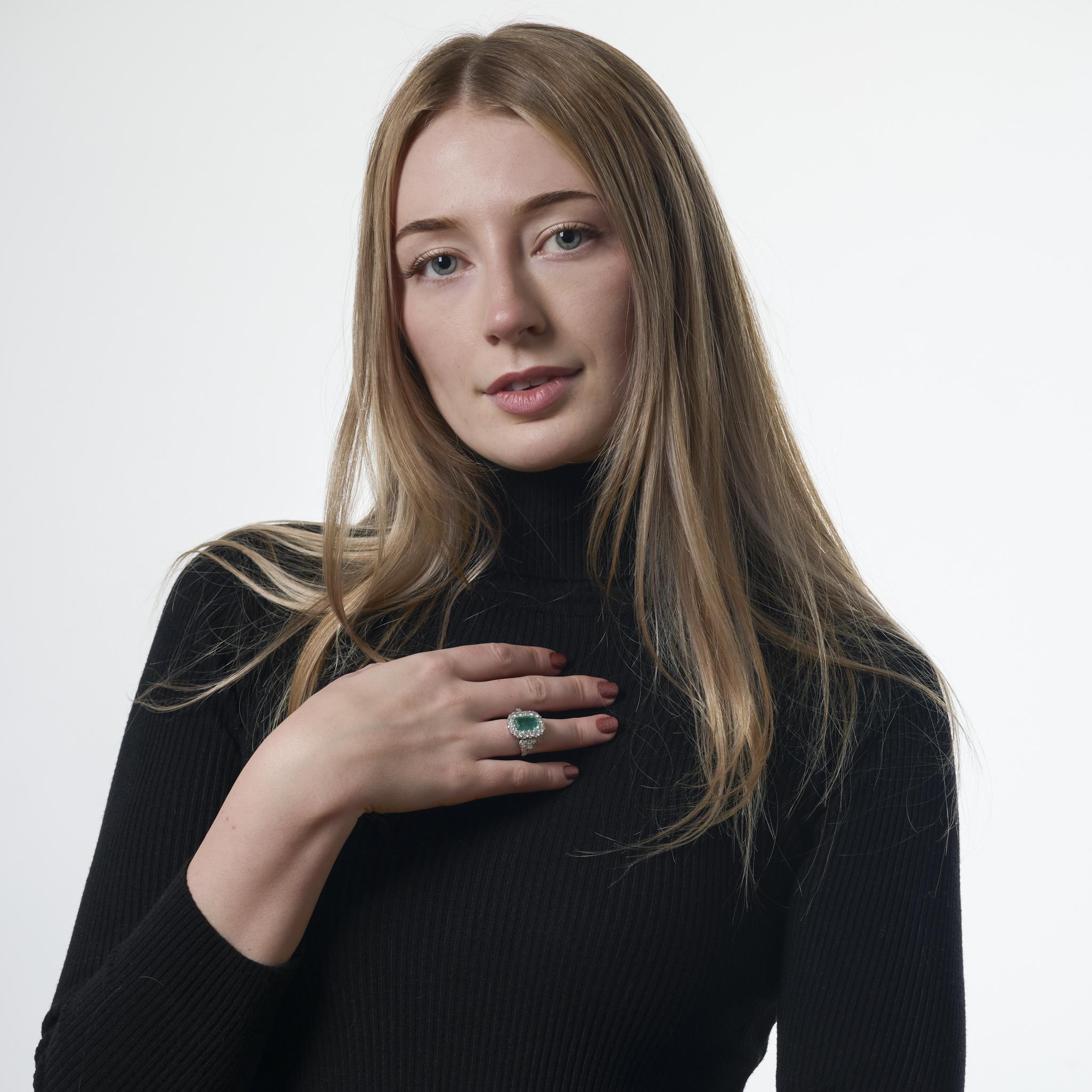 Dieser Vintage-Ring aus Platin aus den 1980er Jahren zeigt einen lebendigen Smaragd von 2,40 Karat im Smaragdschliff, der von 47 runden Diamanten im Brillant- und Einzelschliff von insgesamt etwa 1,50 Karat wunderschön akzentuiert wird. Die