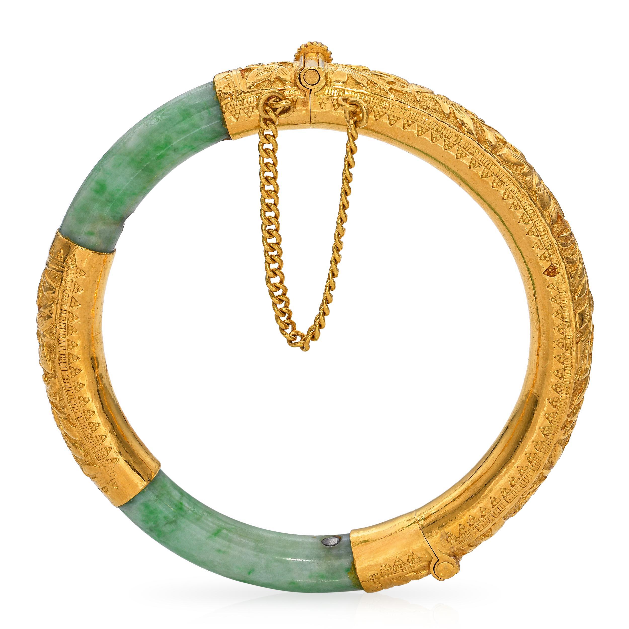 Realizzato in oro, questo braccialetto con cerniera presenta squisiti segmenti di giada verde. La vibrante giada contrasta magnificamente con il ricco oro, creando un fascino visivo sorprendente. Intricati disegni incisi adornano le sezioni in oro,