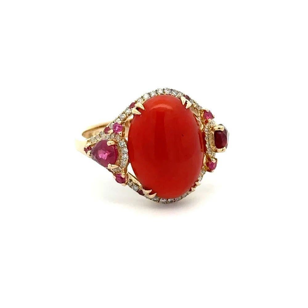 Sencillamente hermoso Anillo de Oro Coral, Diamante y Rubí. En el centro hay un coral ovalado de unos 2,5 quilates, rodeado de diamantes redondos de talla brillante de unos 0,44 quilates y realzados a ambos lados con rubíes de unos 1,00 quilate.