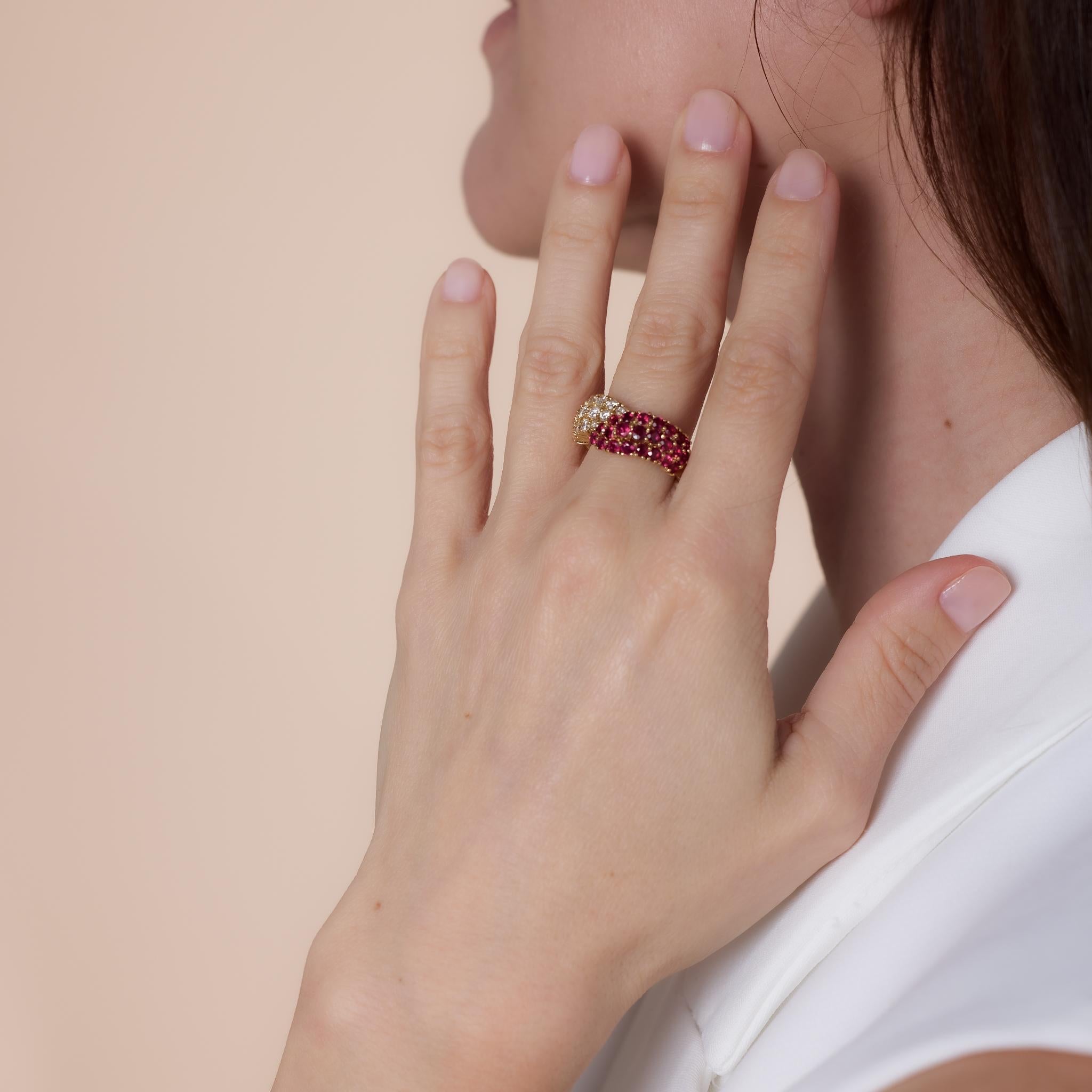 This vintage 18k yellow gold bypass ring showcases 23 round brilliant cut rubies totaling approximately 1.70 carats, accented by 18 round brilliant cut diamonds weighing .80 carats, F color, and VS clarity. Crafted in the 2000s, it is hallmarked