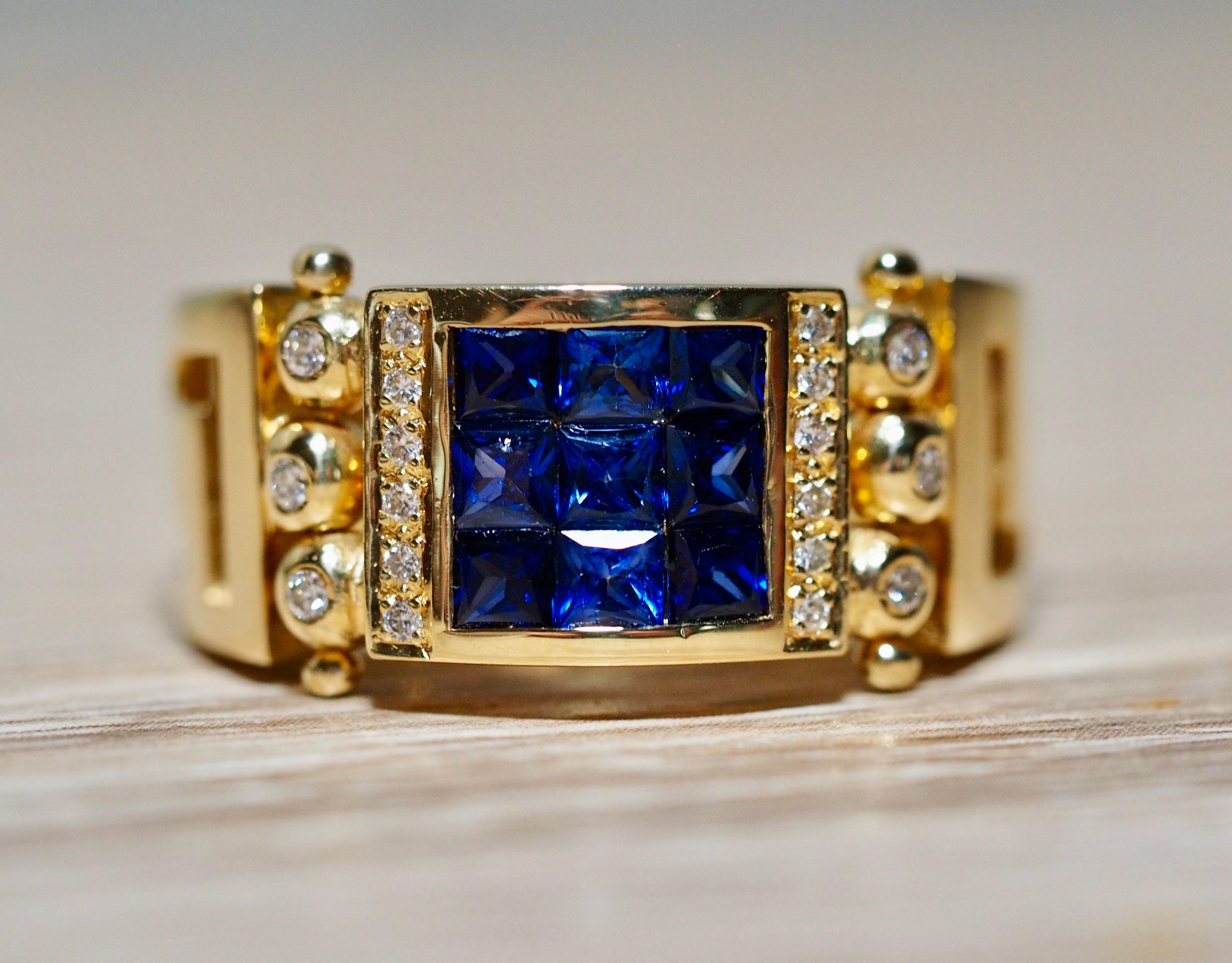 This incredible sapphire ring is detailed at every angle. The square center is made up of nine invisible set squared cut vibrant blue natural sapphires. The sapphires are framed in a yellow gold bezel with a row of diamonds on each side. Next to the