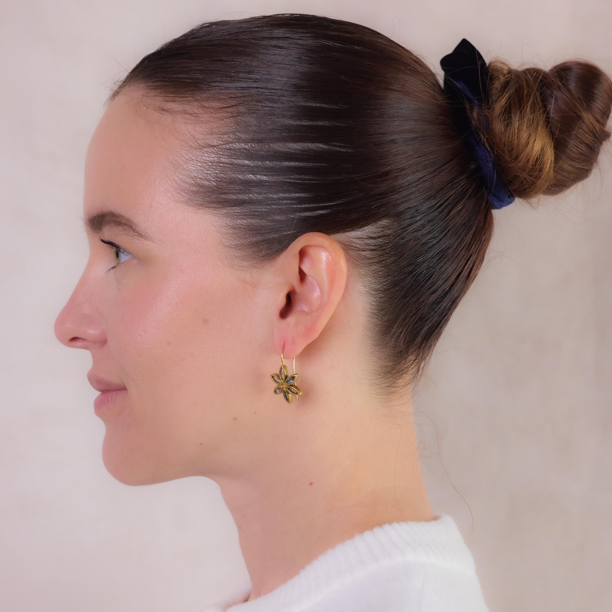 Diese Blumenohrringe aus mattem 18-karätigem Gelbgold sind mit 12 blauen Turmalinen im Marquiseschliff besetzt, die zusammen etwa 2,50 Karat ergeben. Das organische, florale Design strahlt zeitlose Eleganz aus, wobei die Schönheit der Edelsteine
