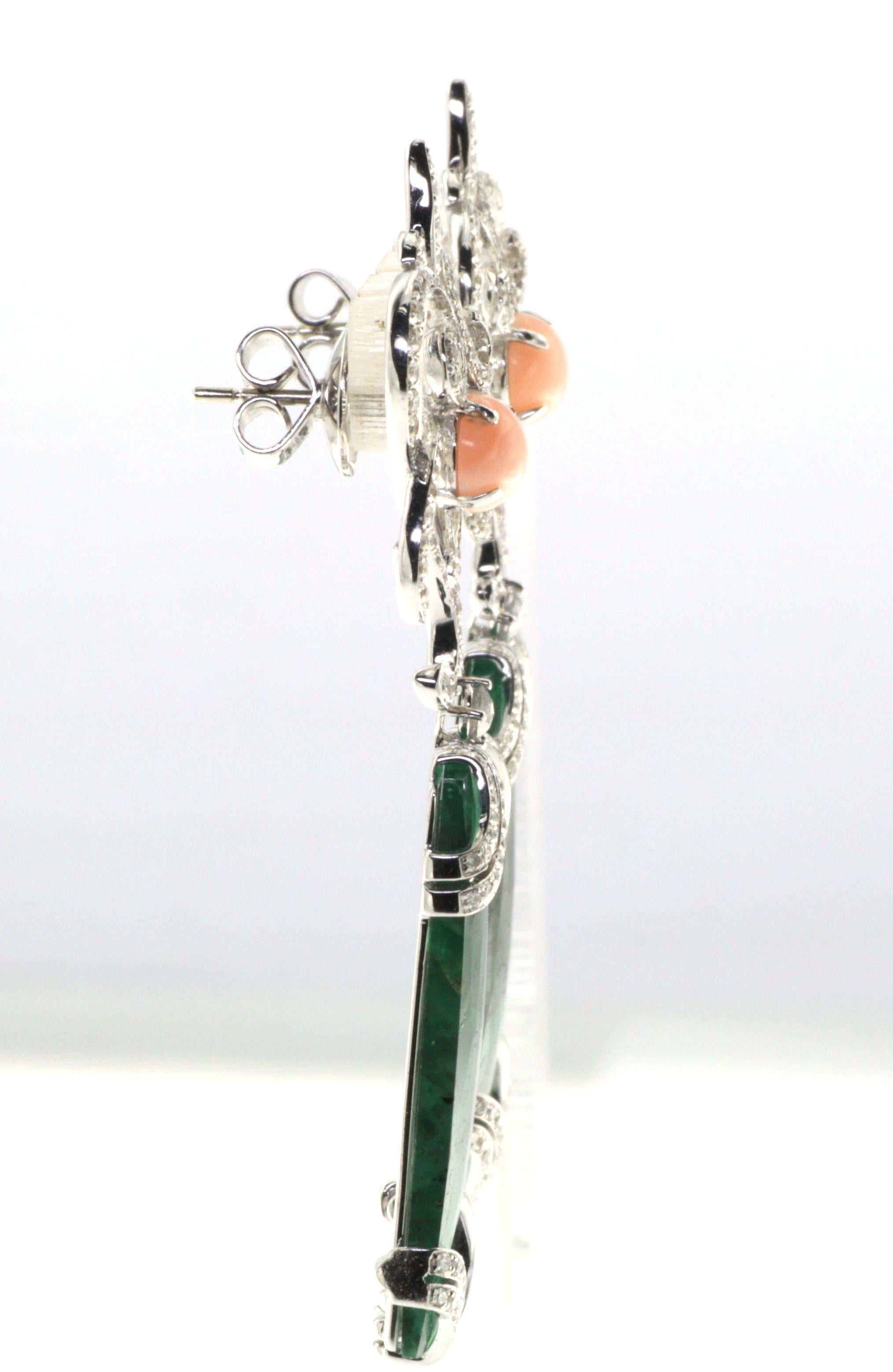 Introducing our exquisite Vintage Emerald Dangle Earrings, adorned with diamonds and coral, set in 18 Karat White Gold. These earrings are a true testament to elegance and sophistication.

At the top of each earring, two beautiful coral gemstones