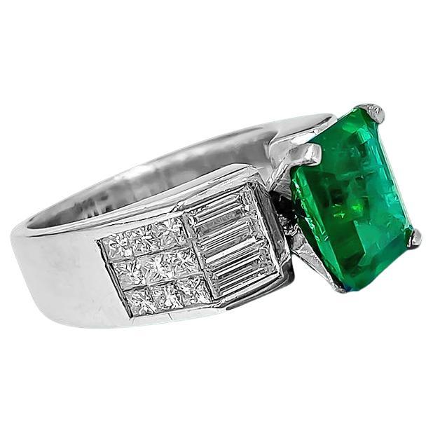 Adorn yourself in elegance with our Solid 18K White Gold Diamond and Emerald Ring, featuring a captivating 2.50 carat princess-cut emerald set in prongs. Complemented by a total of 1.00 carat diamonds, including both baguette and princess cuts, each