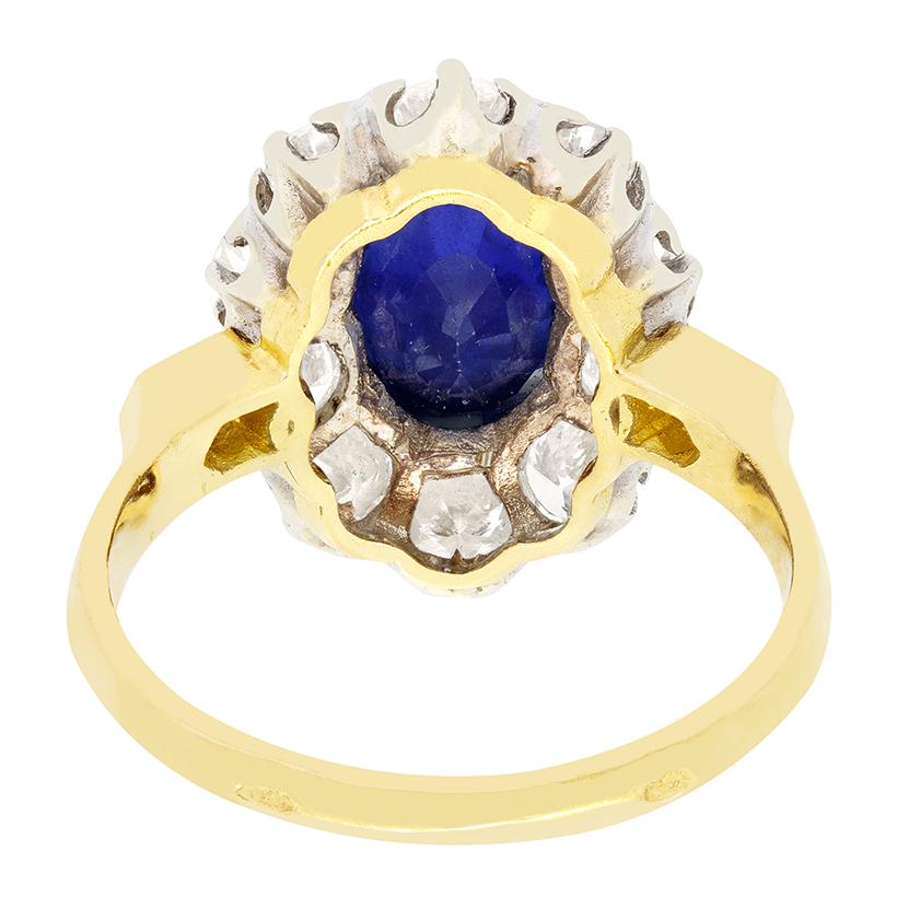 Ein intensiver blauer Saphir steht im Mittelpunkt dieses Vintage-Clusterrings, der von runden Brillanten umgeben ist. Der beheizte Saphir ist ein großer Stein von 2,50 Karat im Ovalschliff, der fachmännisch in Platin gefasst ist. Der Diamantring,