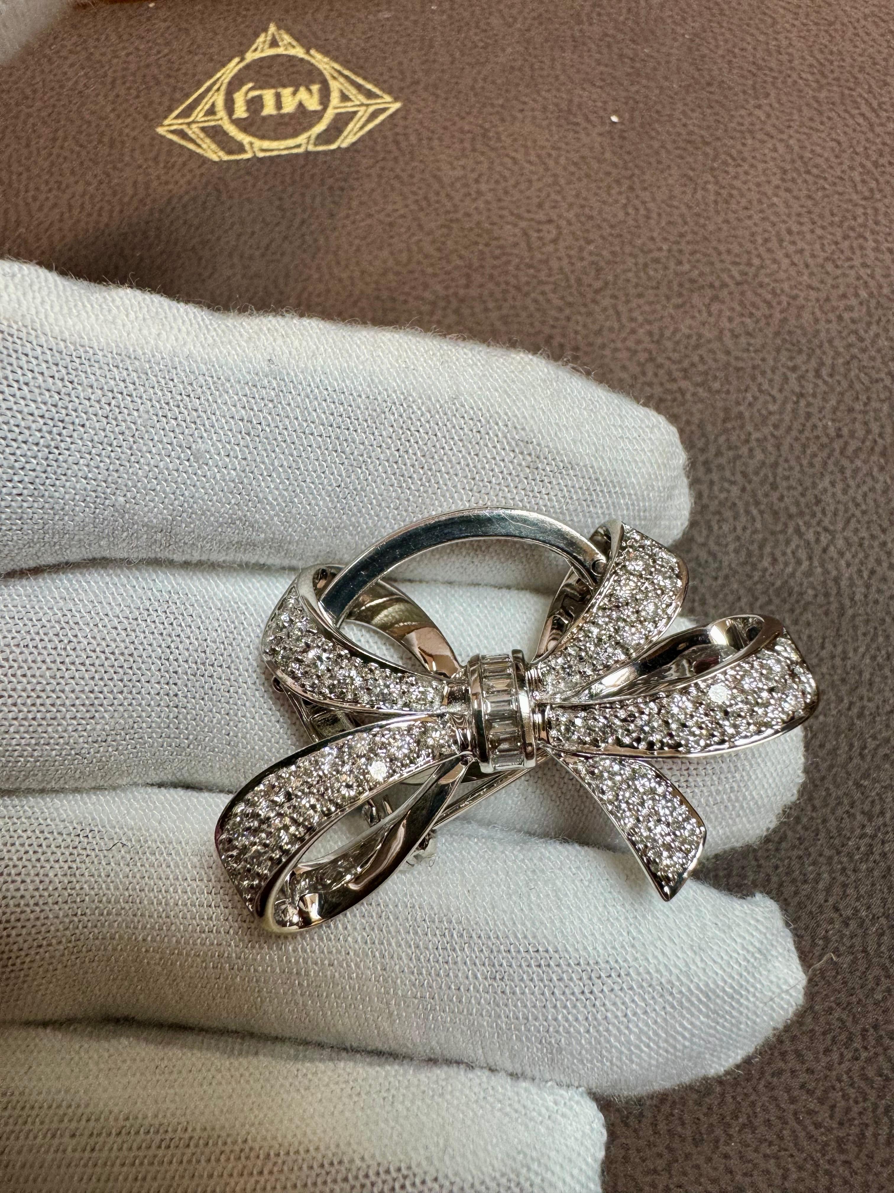 A  bow brooch / Pendant crafted in 18 Karat white gold and densely set with sparkling bright white (G-H color) baguette (in the center) and round cut diamonds.

Estimated total diamond weight 2.55 ct.

Width 1 .5 Inches
This can be used as a