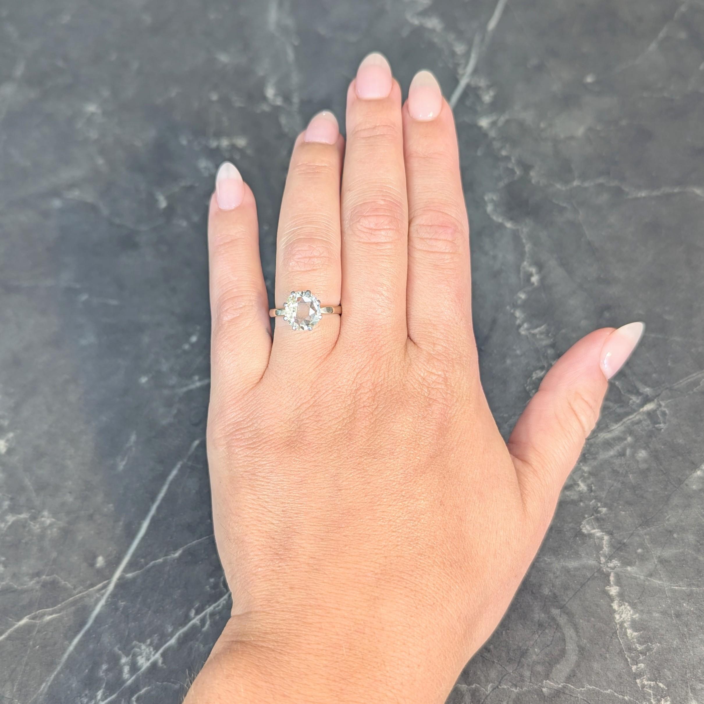 Centering a modified oval cut diamond weighing 2.58 carats - W to X color with SI2 clarity
Prong set in a pierced tear-drop motif platinum basket 
Flanked by tapered and squared-off shoulders
Yellow gold with platinum inner shank
Stamped for 18