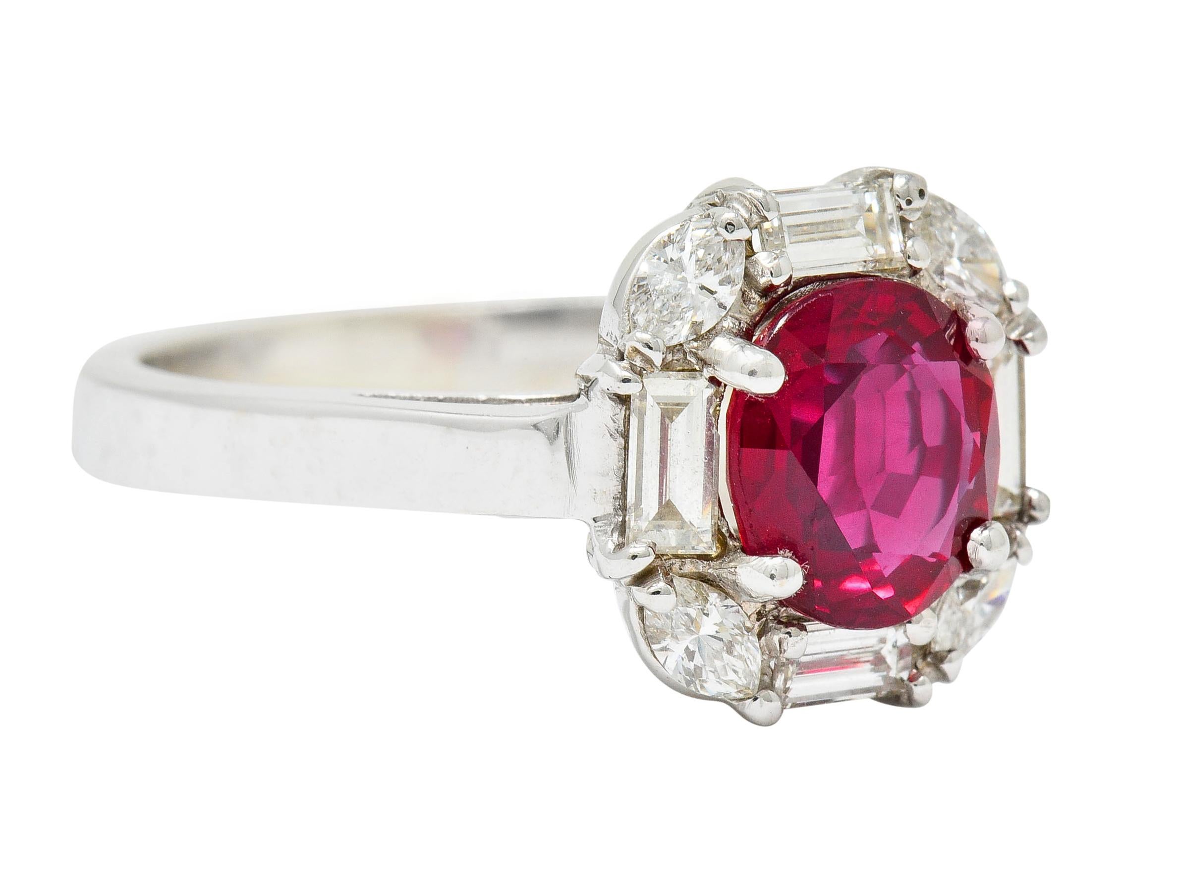 Cluster style ring centering an oval mixed cut Mozambique ruby weighing approximately 1.80 carats, intensely red in color

With baguette cut diamonds at each cardinal direction and marquise cut diamonds at each corner forming a nice cushion shaped