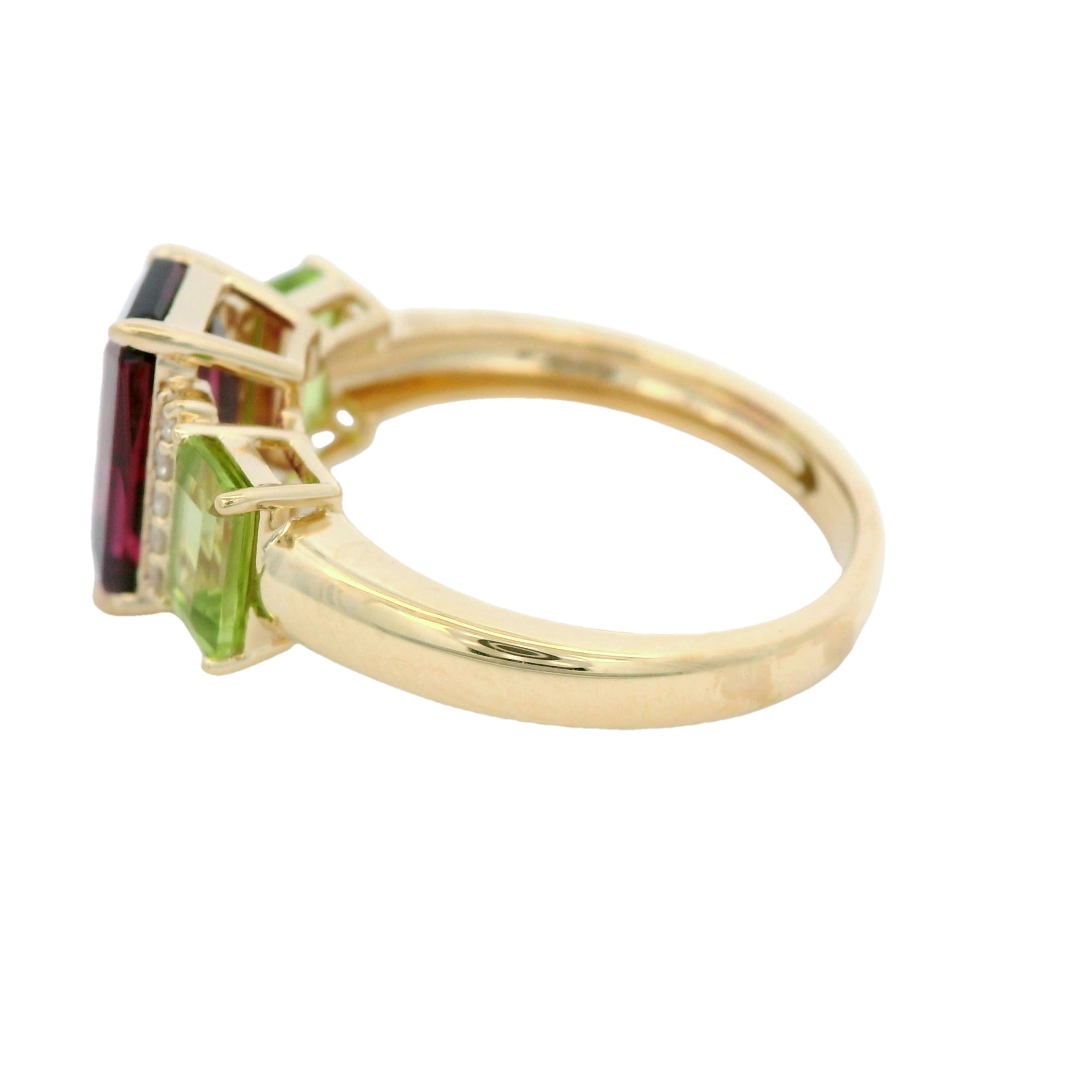 Indulge in timeless elegance with this stunning 14-karat yellow gold ring.     Featuring a captivating 2.61-carat garnet as the centerpiece, this design exudes vibrant sophistication.     The garnet is flanked by two lush peridot gemstones (1.15