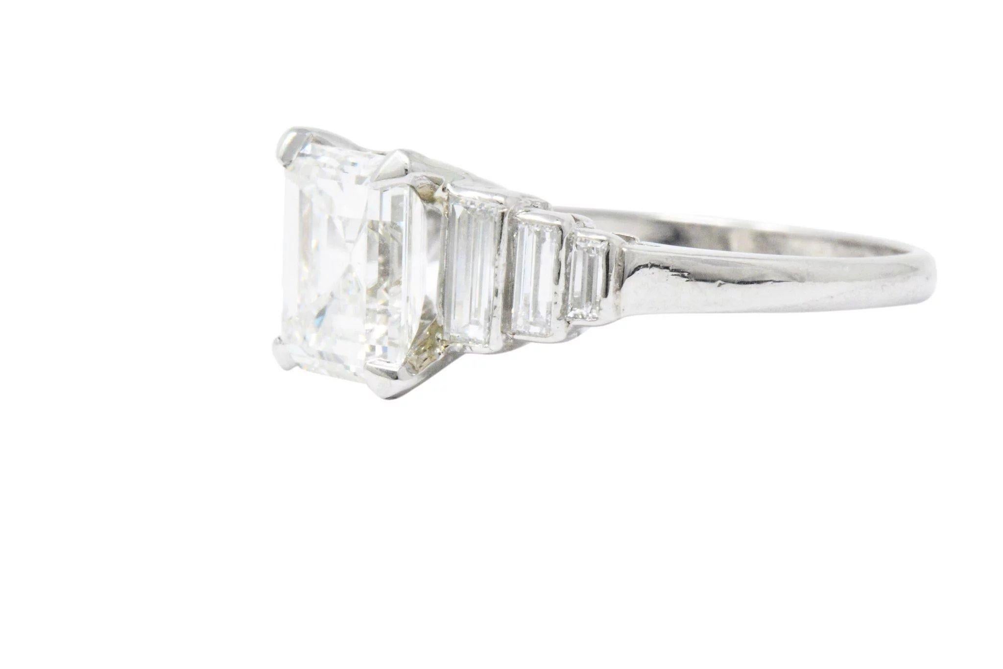 Centering a basket set emerald cut diamond weighing 2.11 carats, I color with VS1 clarity

Flanked by stepped shoulders featuring bezel set baguette cut diamonds weighing approximately 0.60 carat; G to I color with VS clarity

Tested as