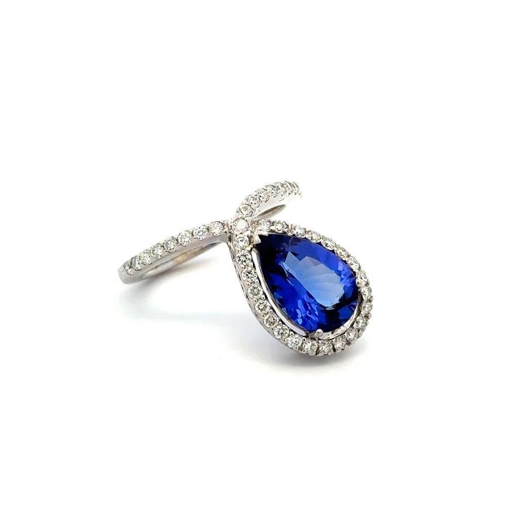 Simply Beautiful! Pear Tanzanite and Diamond Solitaire Gold Ring. Centering a securely nestled Hand set 2.75 Carat Tanzanite, surrounded by Round Brilliant Cut Diamonds, weighing approx. 0.63tcw. Hand-crafted 14K White Gold Bias mounting. Ring size: