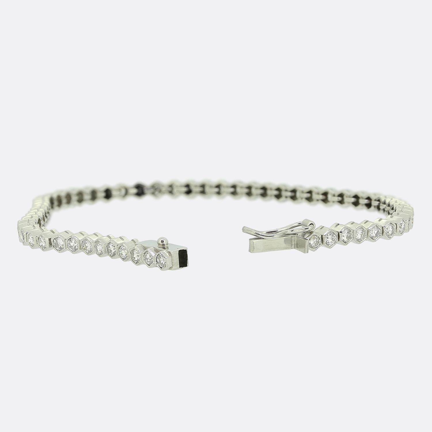 Here we have a delightful diamond set line bracelet. This vintage piece has been crafted from platinum and showcases 59 round brilliant cut diamonds; each of which sits individually in a hexagonally shaped milgrain setting. All stones here are