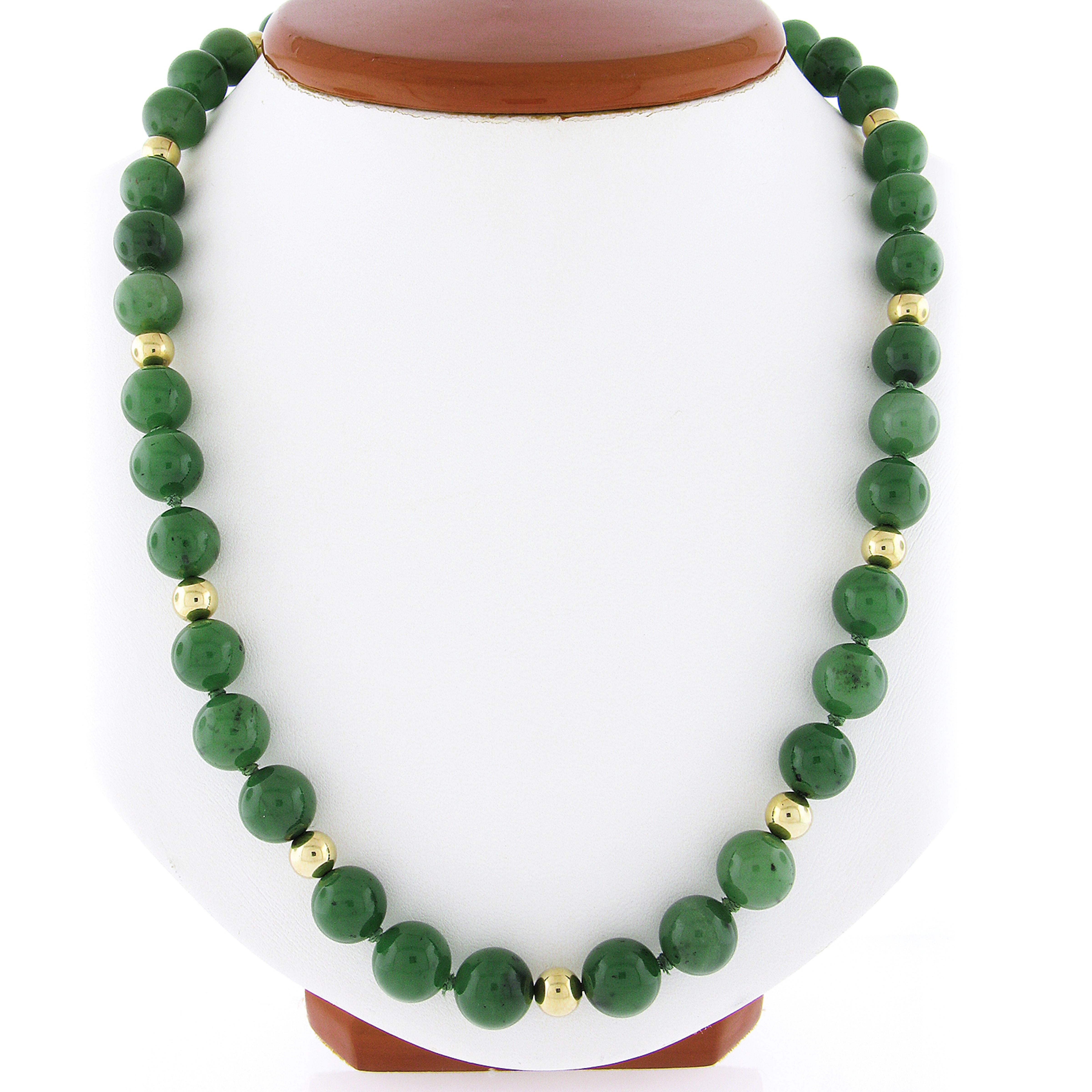 Ecco una magnifica collana vintage con 55 perle di giada nefrite autentica, ordinatamente infilate ed elegantemente accentuate da stazioni di perle lucidate in oro giallo 14k. Queste bellissime perle di giada presentano bellissimi e naturali colori