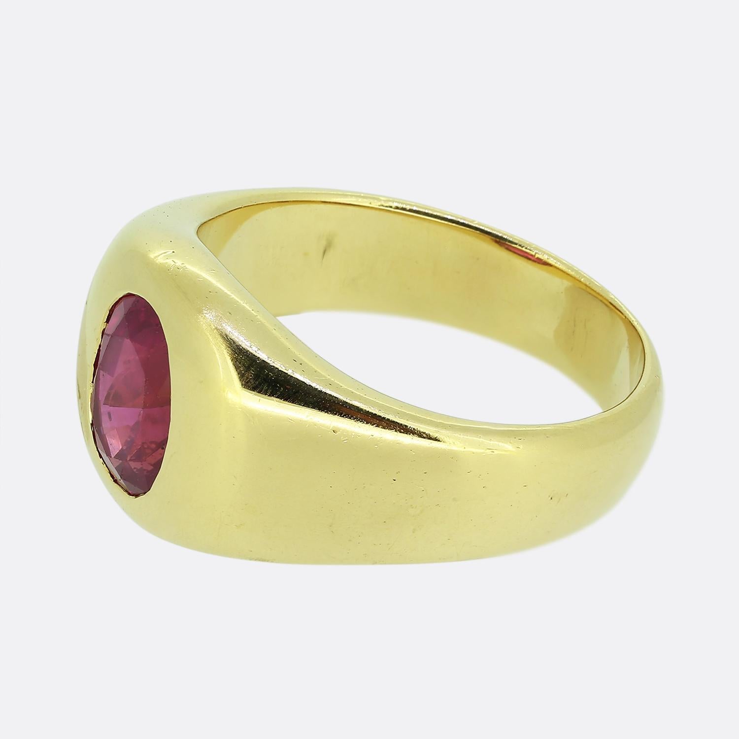 Here we have a stunning single stone ring. This vintage piece has been crafted from a warm 18ct yellow gold and showcases an oval faceted natural ruby at the centre of the face in a rub-over setting amidst a pair of wide unembellished shoulders.