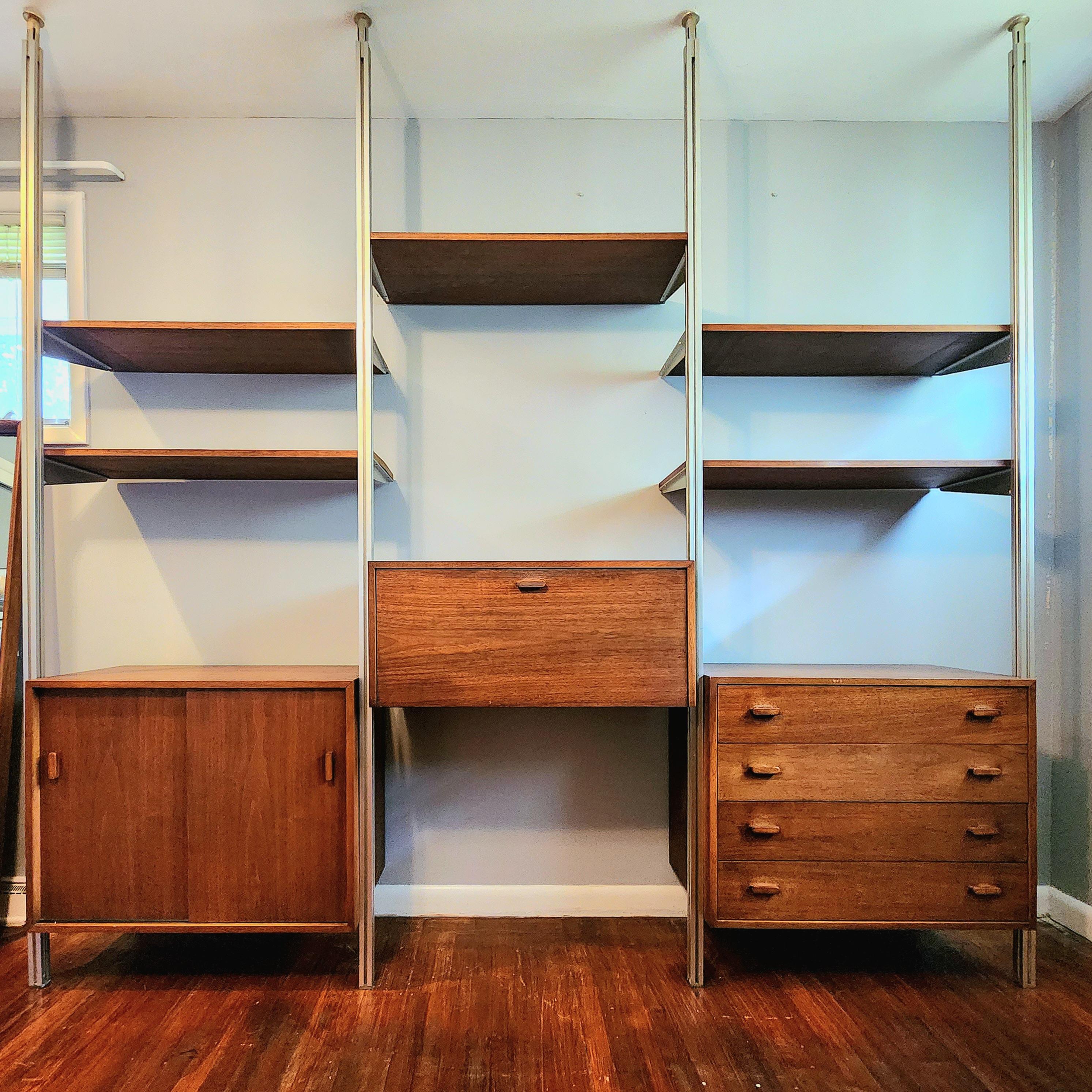 Beautiful 3 bay Omni wall unit by goerge nelson. walnut with floor to ceiling aluminum uprights.

