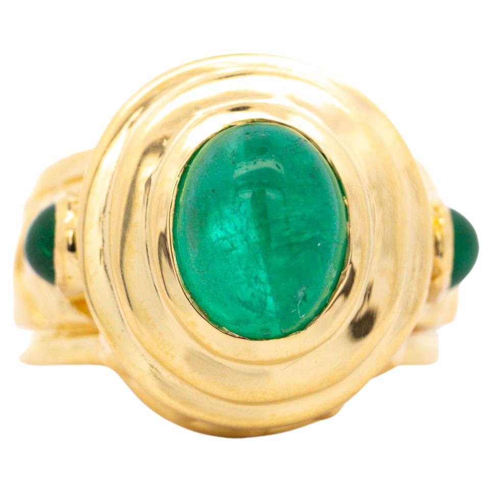A vintage treasure featuring a stunning 3-carat Colombian emerald cabochon set in 20K yellow gold. The cabochon-cut emerald, exuding rich green hues, commands attention with its captivating sheen.

This ring boasts a unique carved chevron and