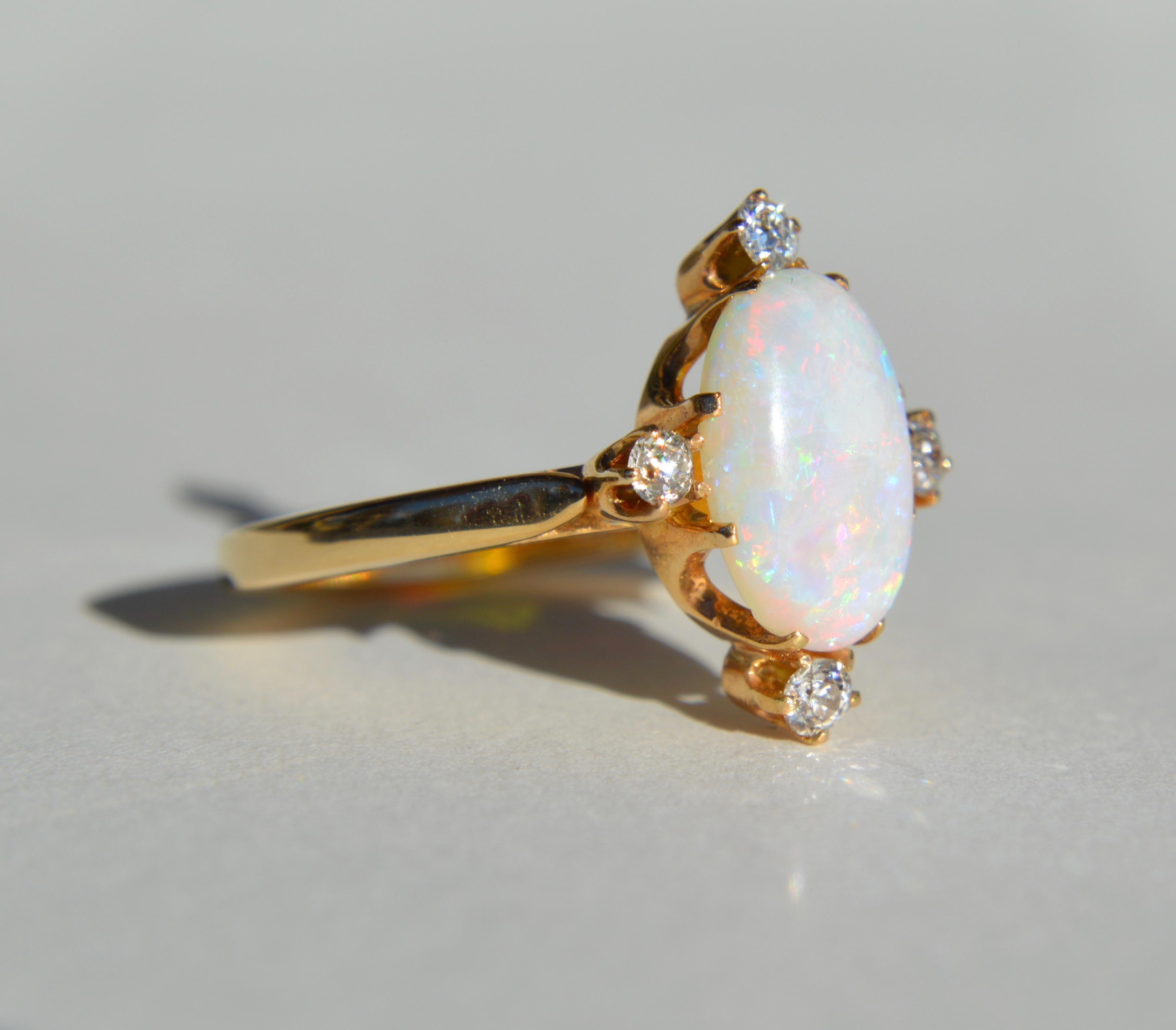 Beautiful vintage circa 1980s 14K yellow gold featuring a 3 carat fiery rainbow flecked Australian opal cabochon with 4 round cut diamonds, each .11 carat (3mm diameter).  In very good condition. Ring is unmarked but acid tested as solid 14K gold.