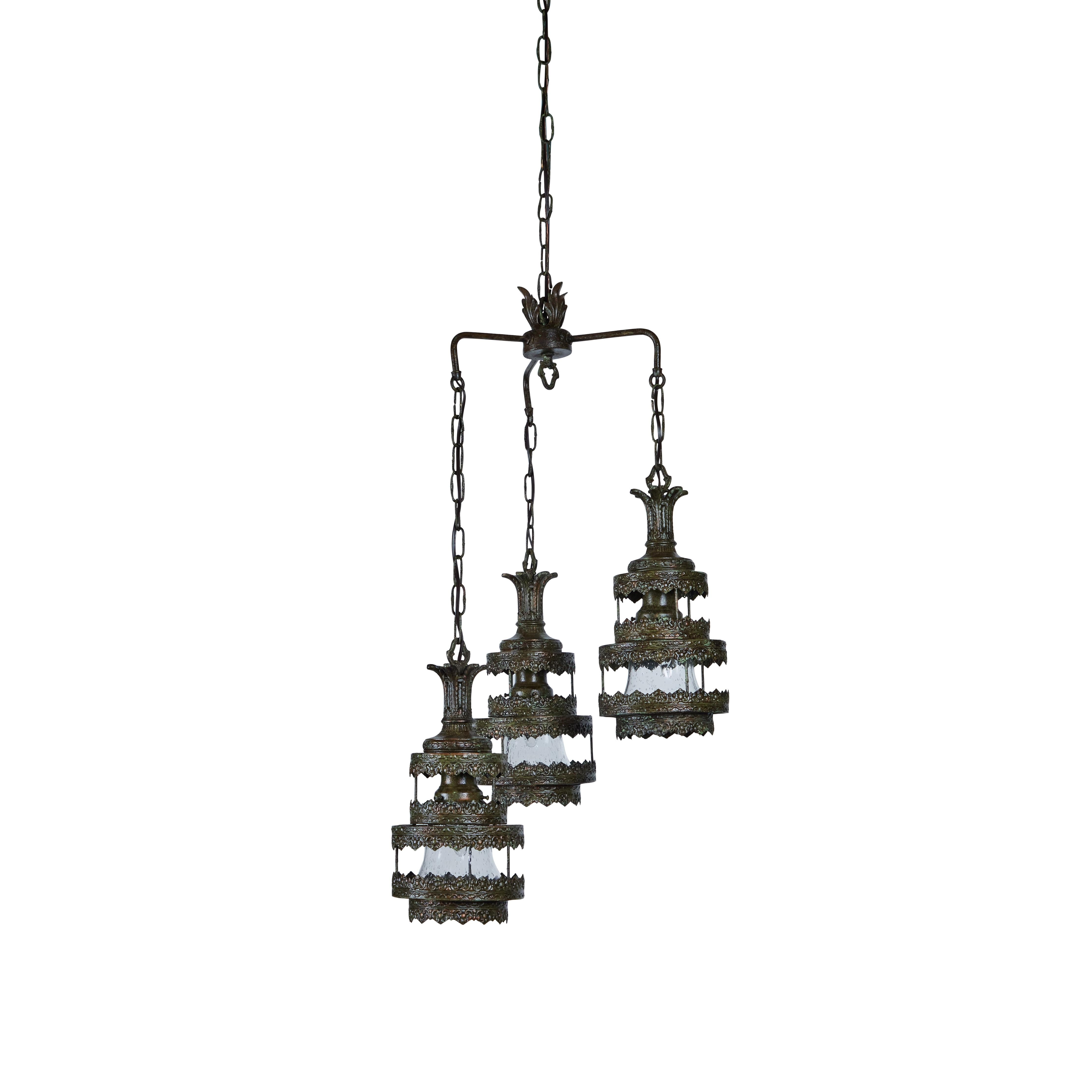 This dramatic vintage 3-drop hanging pendant light is quite a statement.
The entire fixture has been newly refinished in an aged golden green finish and each pendant drop has new bubble glass insert. Its been newly rewired and measures 14.5