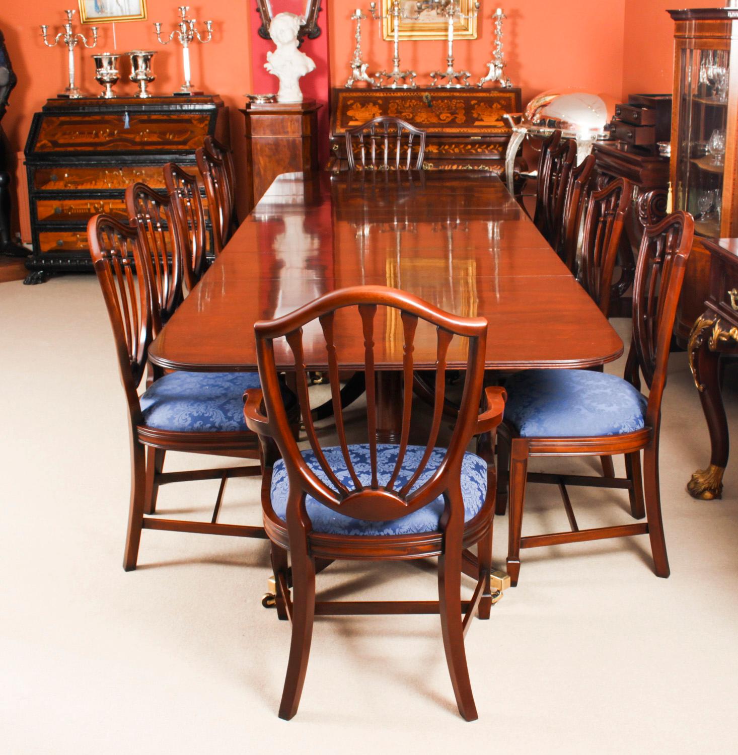 This is fabulous Vintage dining set comprising a Regency style dining table by William Tillman, circa 1980 and a Vintage set of twelve Hepplewhite revival dining chairs.

The table is made of stunning solid flame mahogany and is raised on three