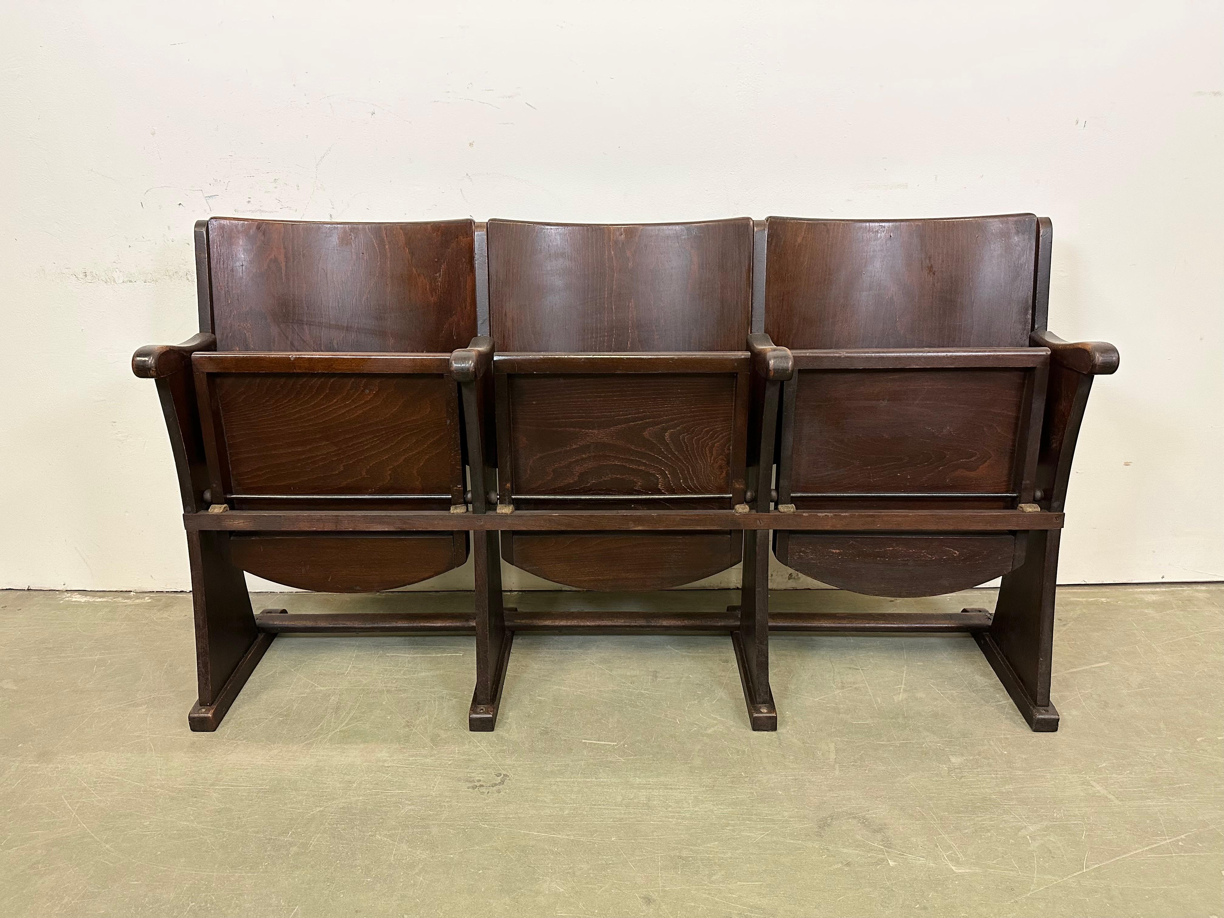 This three-seat cinema bench was produced by Thonet in former Czechoslovakia during the 1930s-1950s. The chairs are stable and can be placed anywhere. It is completely made of wood (partly solid wood, partly plywood). The seats fold upwards. The