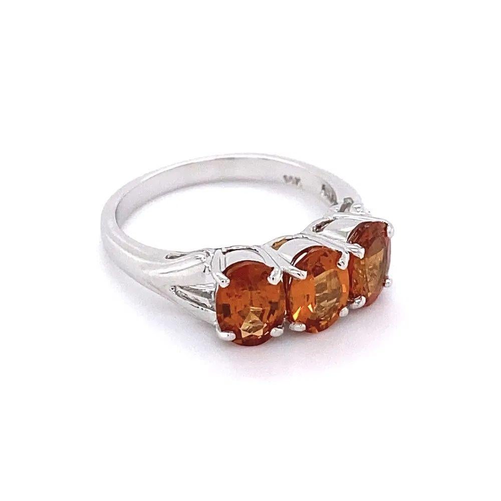 Simply Beautiful! Finely detailed Gold Three-Stone Yellow Spessartite Garnet Trilogy Ring. Securely Hand set with 3 Round Yellow Spessartite Garnets, weighing approx. 2.25tcw. Hand crafted 14K White Gold mounting. The ring epitomizes vintage charm.