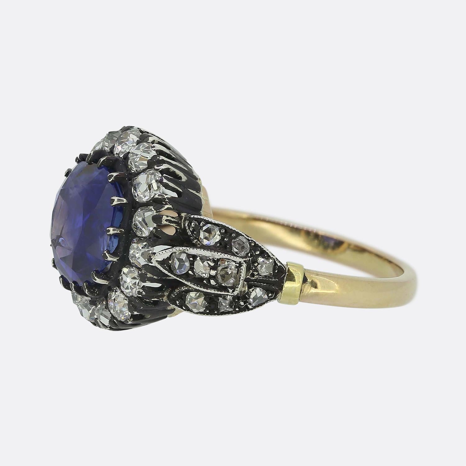 Here we have a simply beautiful sapphire and diamond cluster ring. This vintage piece has been expertly crafted in an early Victorian style and showcases a mesmerising round faceted sapphire of Burmese origin. This principal stone boasts a rich navy