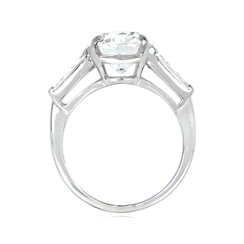 This vintage platinum engagement ring showcases a GIA-certified round brilliant diamond weighing 3.04 carats (I color, SI2 clarity), with tapered baguette cut diamonds on each shoulder weighing a total of approximately 0.72 carats. The ring dates