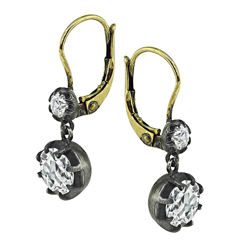 This is a gorgeous pair of silver and gold earrings. The earrings feature sparkling 2 large old mine cut diamonds that weigh approximately 2.38ct. The color of these diamonds is J-K with VS1 clarity. The two large diamonds are accentuated by two