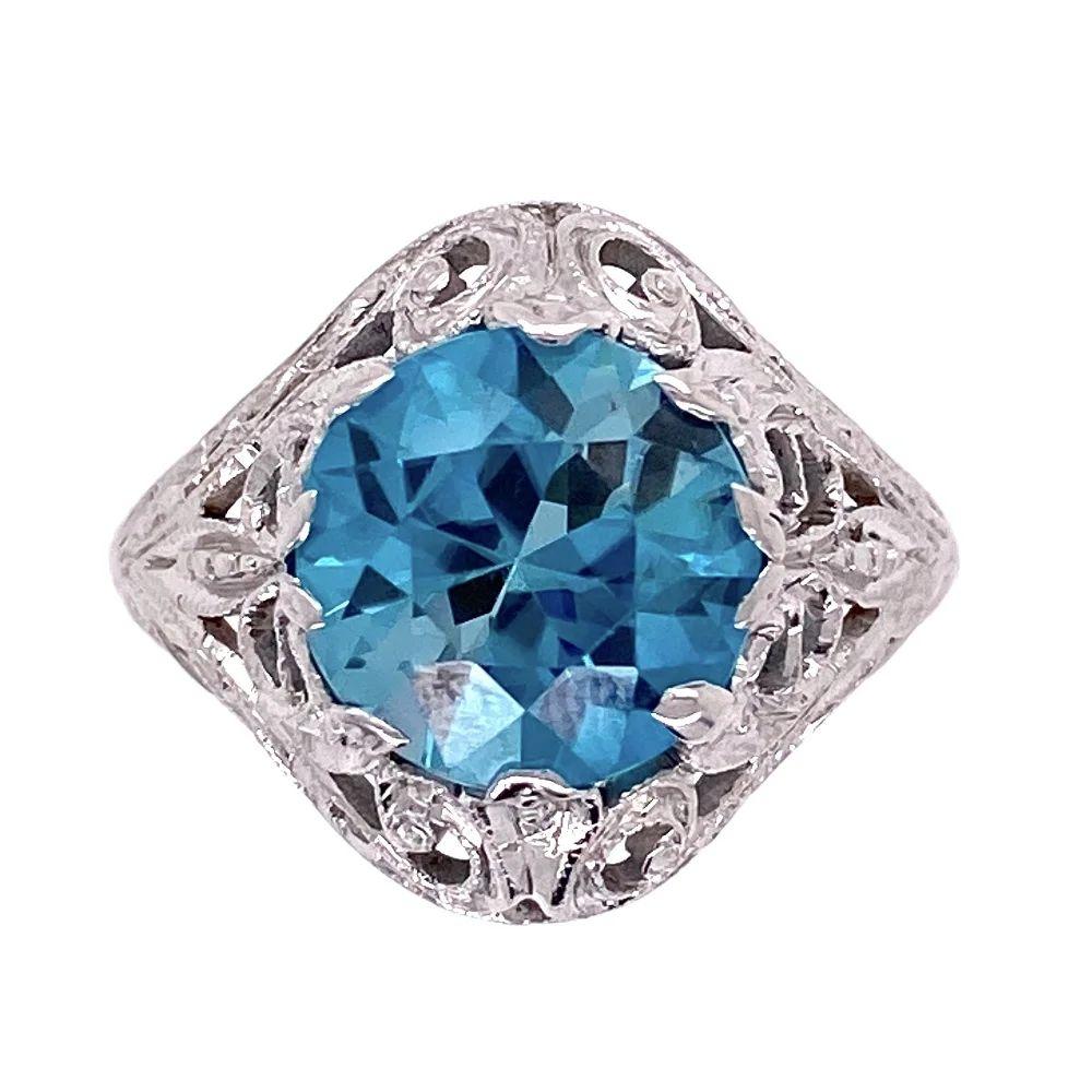 Simply Beautiful! Finely detailed Round Blue Zircon Art Deco Gold Cocktail Ring. Centering a Hand set securely nestled 3.20 Carat Round Deep Blue Zircon. Artfully Hand crafted in 14K White Gold mounting. Ring size 6.5, we offer ring resizing. The