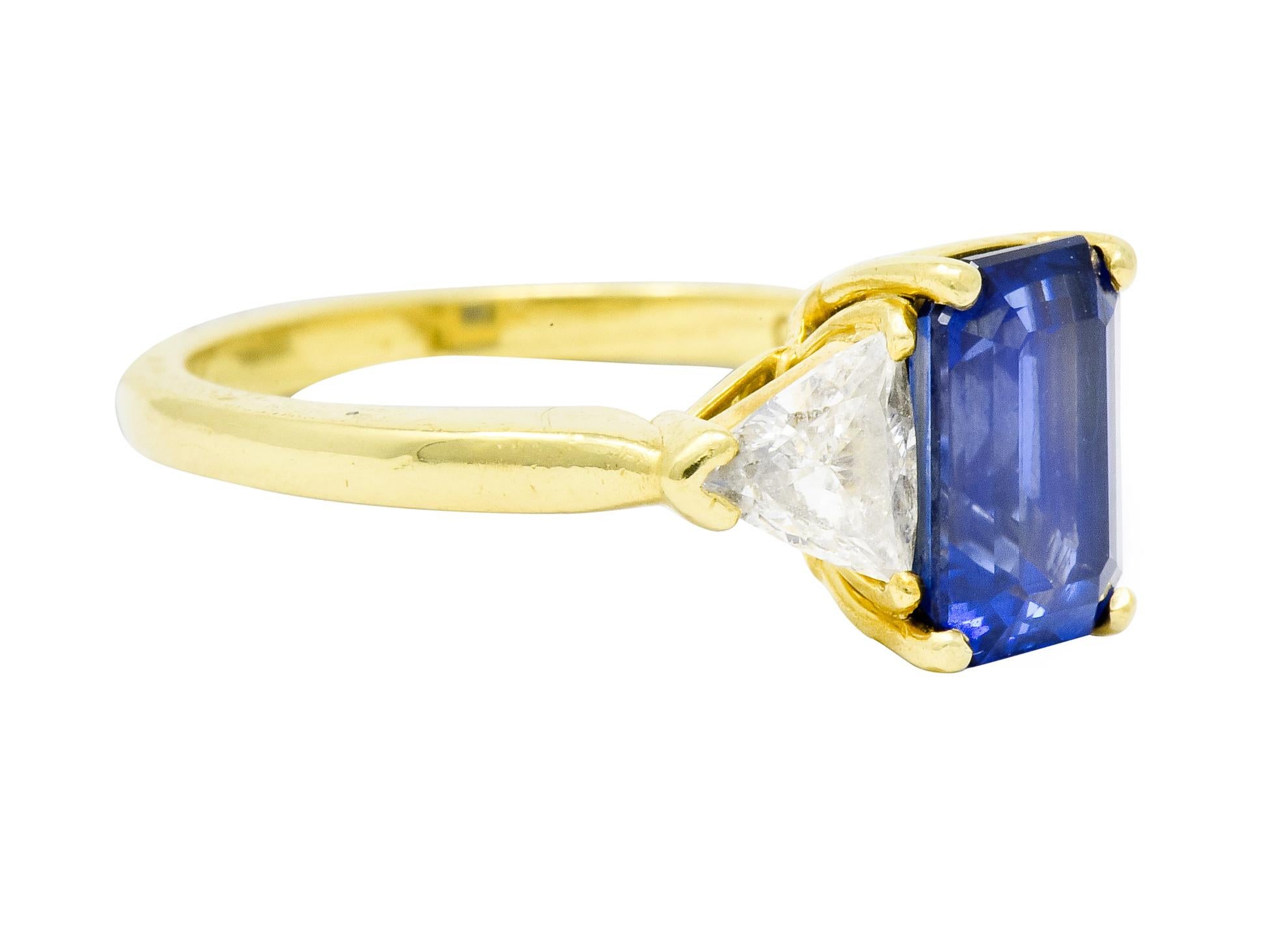 Centering a basket set rectangular step cut sapphire weighing approximately 2.60 carats; eye-clean with bright blue color

Flanked by two trillion cut diamonds weighing in total 0.60 carat, G color with VVS clarity

With maker's mark and stamped 18K