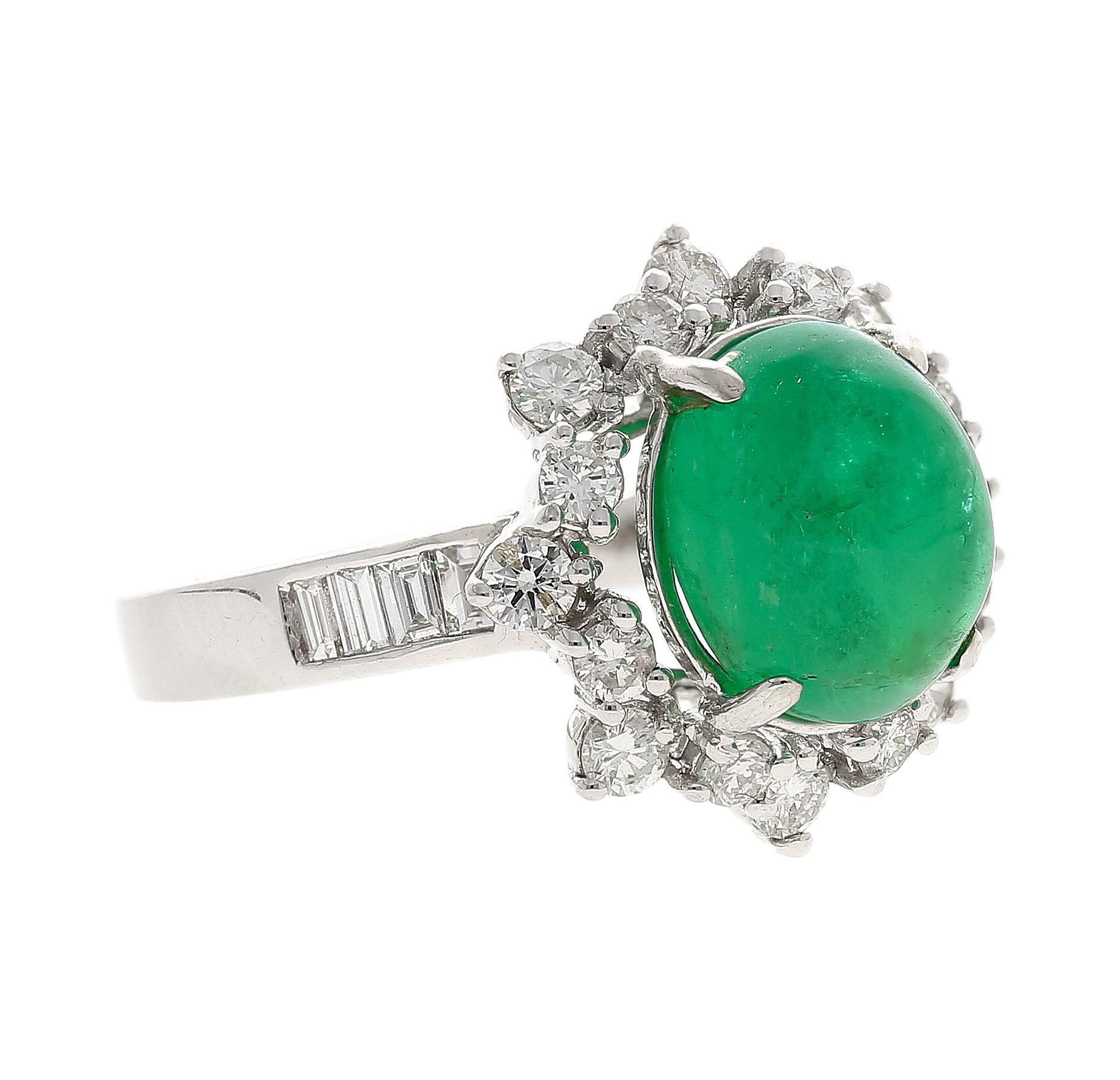 3.32 Carat Emerald and Diamond Ring in 14K White Gold. Large and smooth surface cabochon cut enchanting emerald in the center a 4 prong-setting. Featuring 16 round-cut diamonds surrounding it in a dense and highly textured halo. 4 baguette shaped