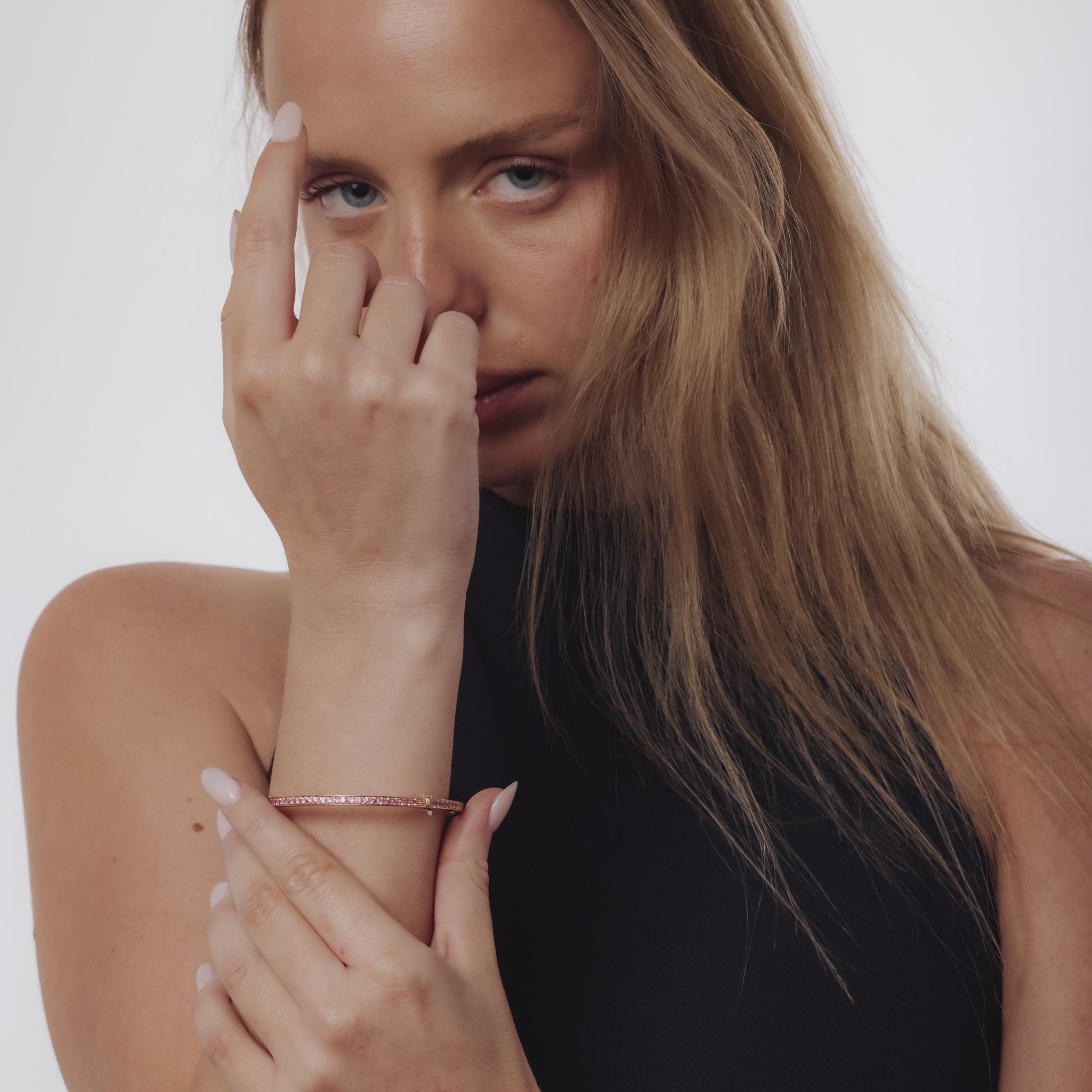 This vintage 1990’s bangle glows with feminine elegance, crafted in warm 18k rose gold and set with 85 round cut pink sapphires totaling approximately 3.40 carats. Their soft yet vibrant hue brings delicate color and charm to the sleek gold design.