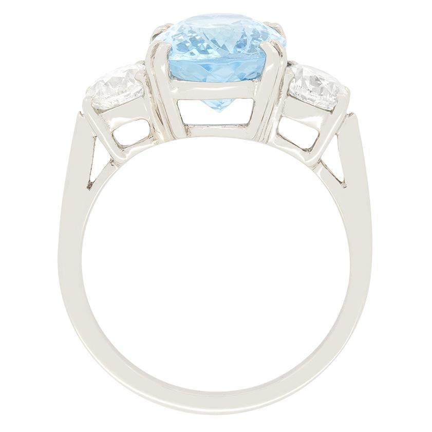 A glorious 3.50 carat oval-shaped aquamarine proudly sits between two twinkling brilliant cut diamonds. The brilliant diamonds combine to 1.00 carat are of I colour and VS-SI clarity. Double platinum claws raise the aqua above the diamonds creating