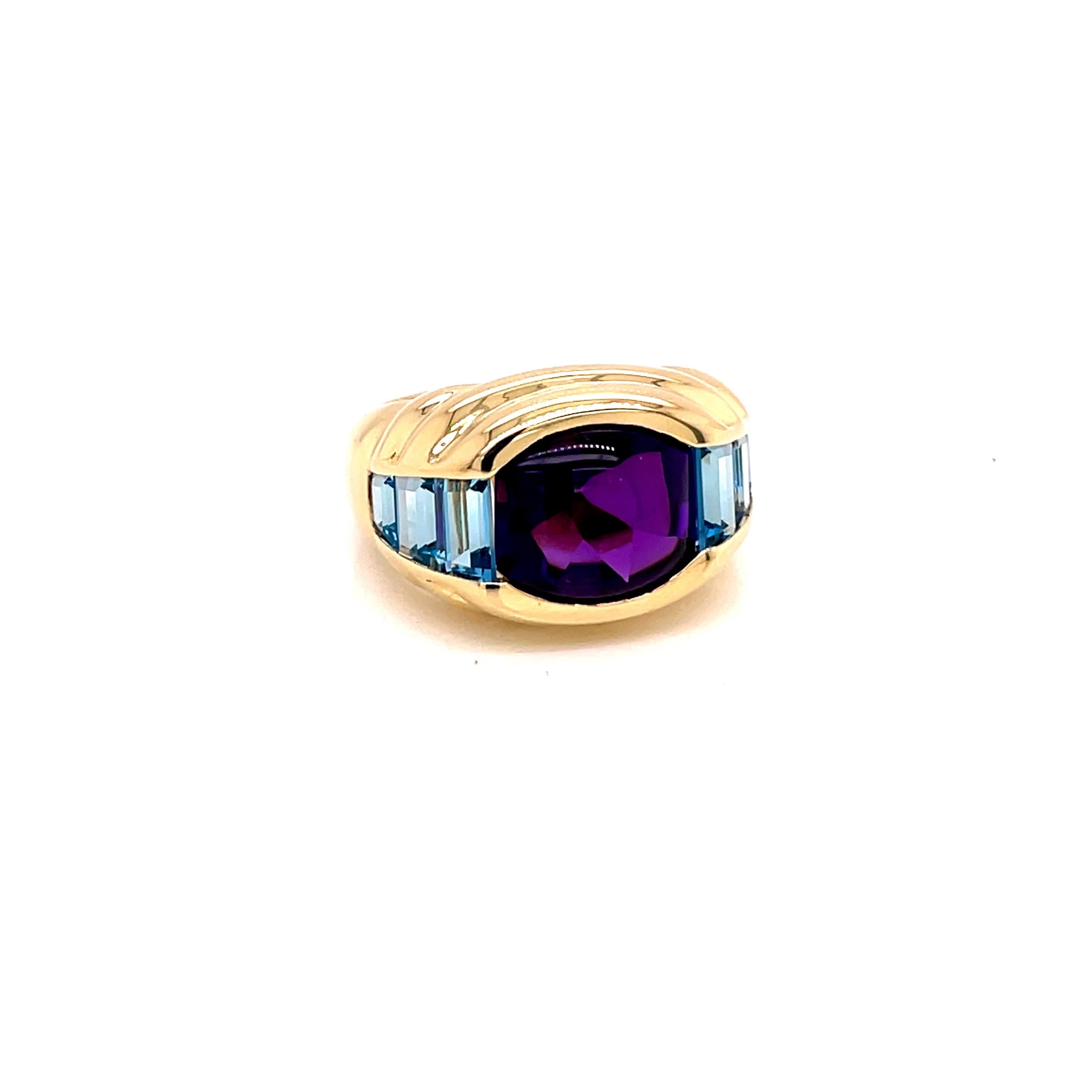 Vintage 1980's 3.50ct  Cabochon Amethyst Ring  - the amethyst weighs approximately 3.50ct and measures 10.5 x 9.5mm.  It is accented with 6 trapezoid blue topaz stones channel set.  The setting is 14k yellow gold  bezel setting with a finger size