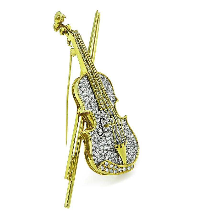 This is a wonderful 14k yellow gold enamel diamond pin. The pin features a very creative violin pin with intricate violin details and realistic strings. The violin features sparkling round cut diamonds that weighs approximately 3.50ct. The color of
