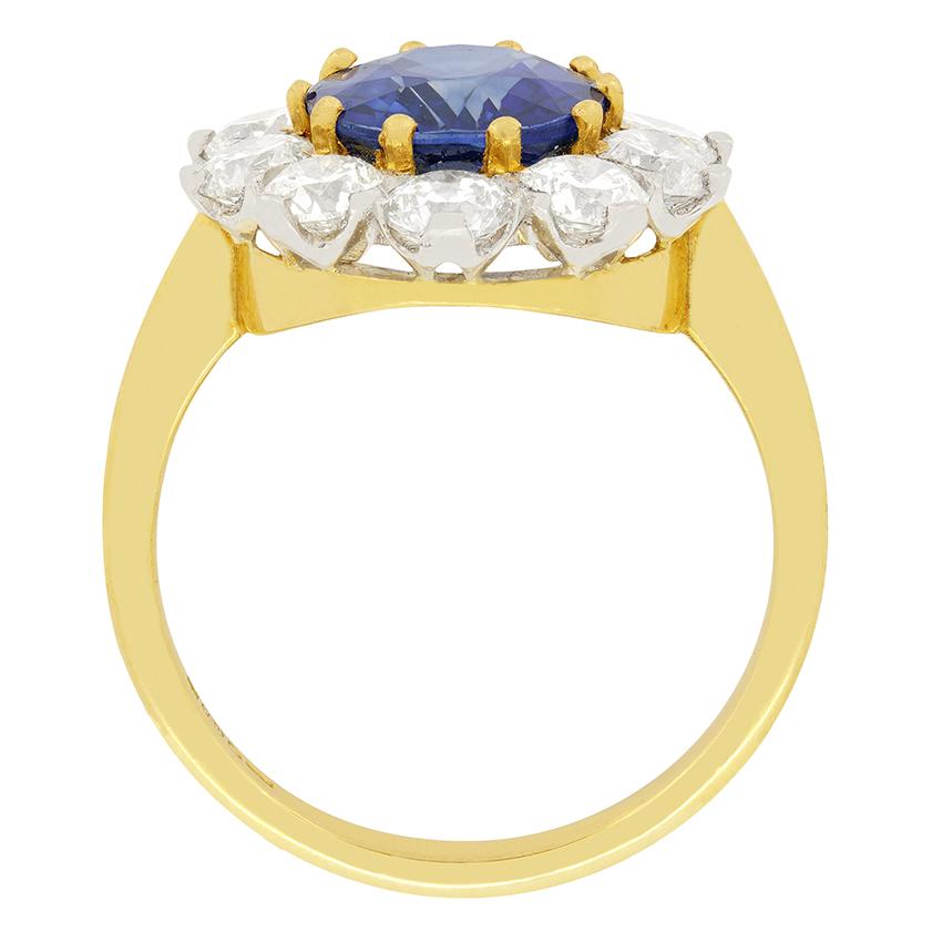 Ein ovaler Saphir von 3,50 Karat wird in diesem auffälligen Vintage-Ring von einem Halo aus Diamanten im Brillantschliff hervorgehoben. Der sattblaue Saphir wurde einer Wärmebehandlung unterzogen, die ihm ein dramatisches Aussehen verleiht. Es gibt