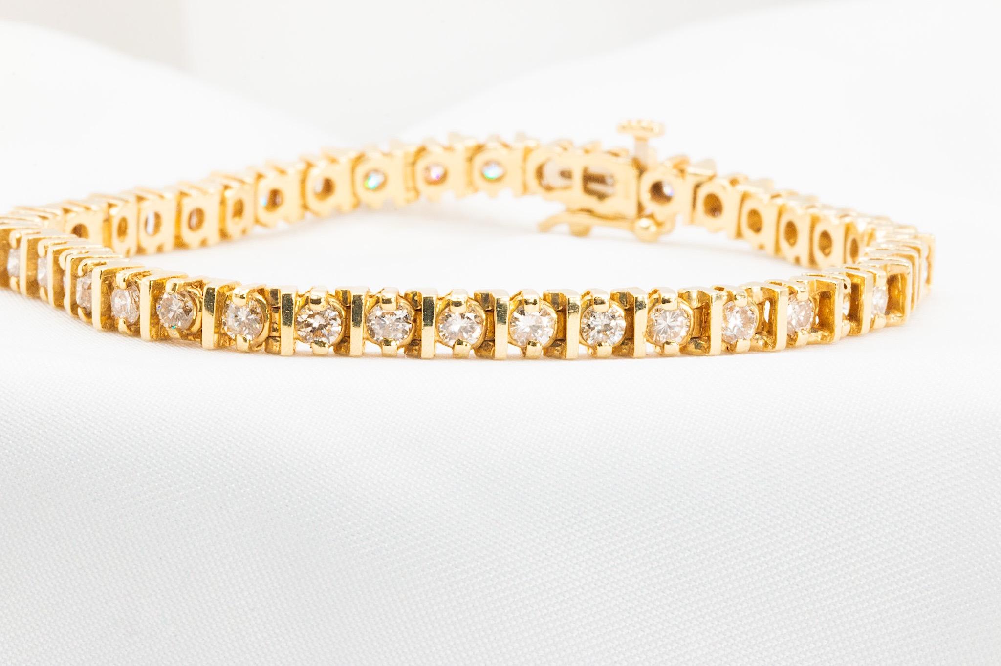 Questo raffinato bracciale tennis d'epoca in oro giallo 14K sfoggia 41 diamanti naturali rotondi con taglio a brillante per un totale di circa 3,54 carati. I diamanti hanno un colore G-H e una purezza VS-SI. 

Il dettaglio della barra tra ogni